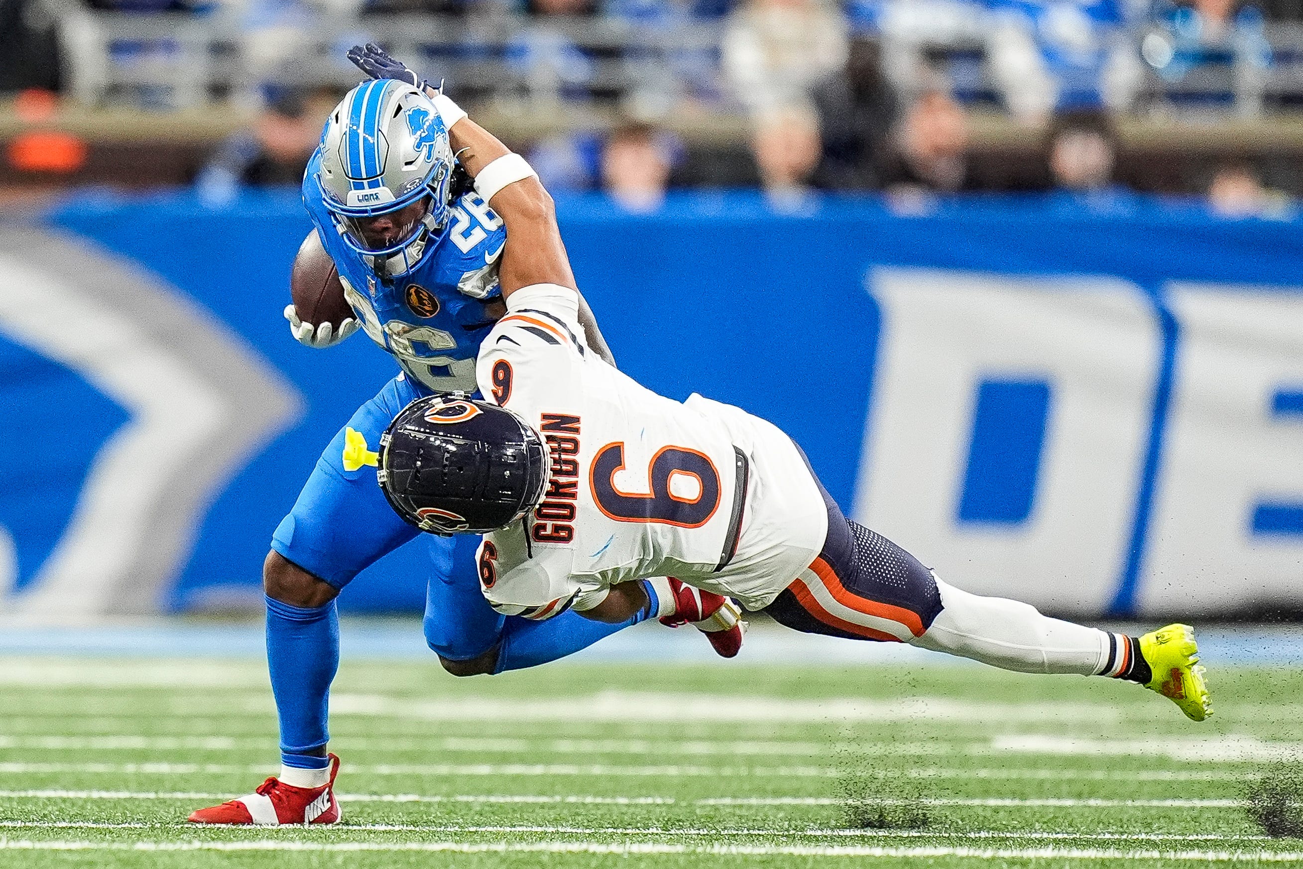 Chicago Bears cornerback Kyler Gordon (6) tackles Detroit Lions running back Jahmyr Gibbs (26) during the second half at Ford Field in Detroit on Thursday, Nov. 28, 2024.
