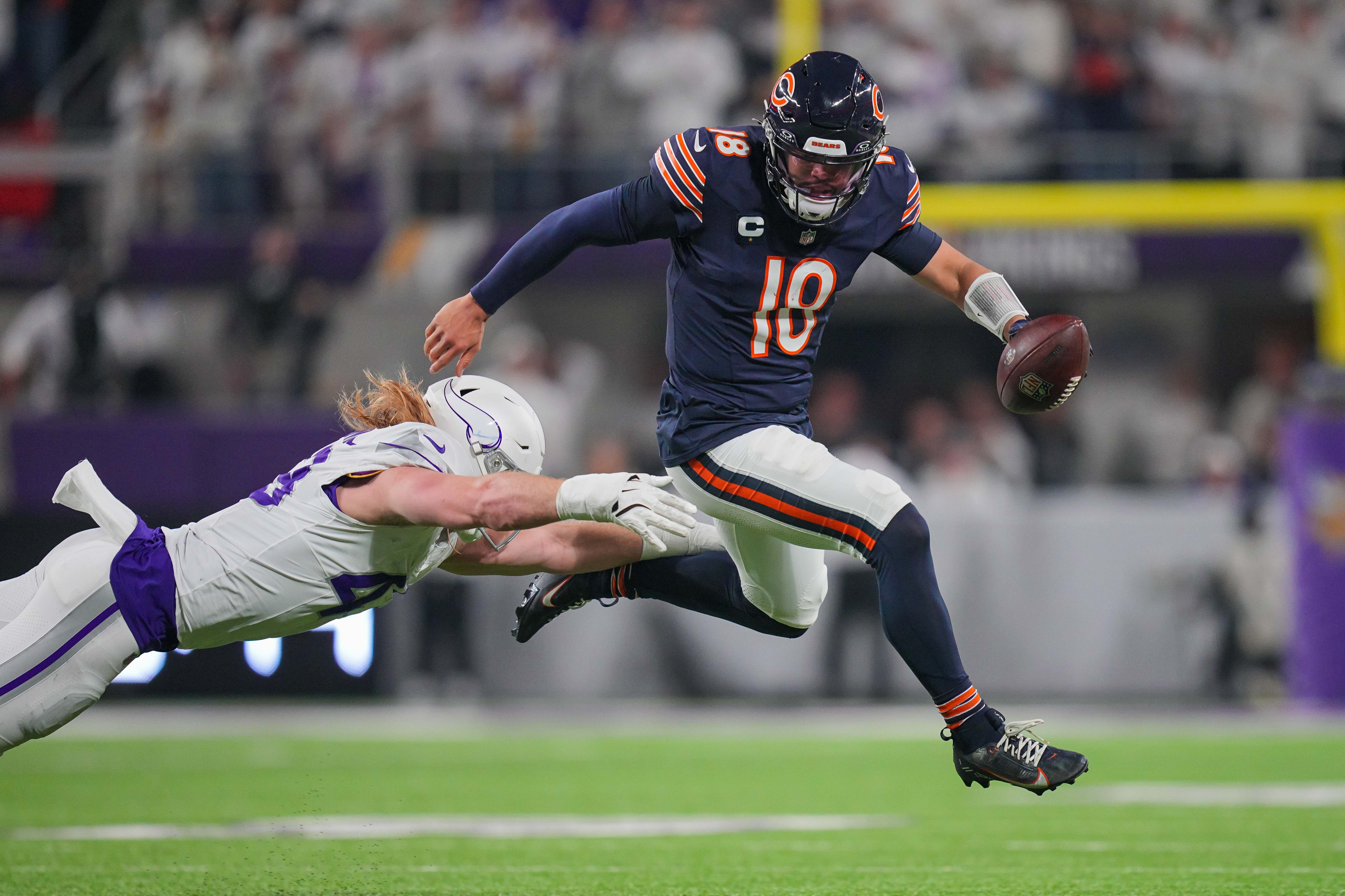 Dec 16, 2024; Minneapolis, Minnesota, USA; Chicago Bears quarterback Caleb Williams (18) scrambles against the Minnesota Vikings linebacker Andrew Van Ginkel (43) in the second quarter at U.S. Bank Stadium.