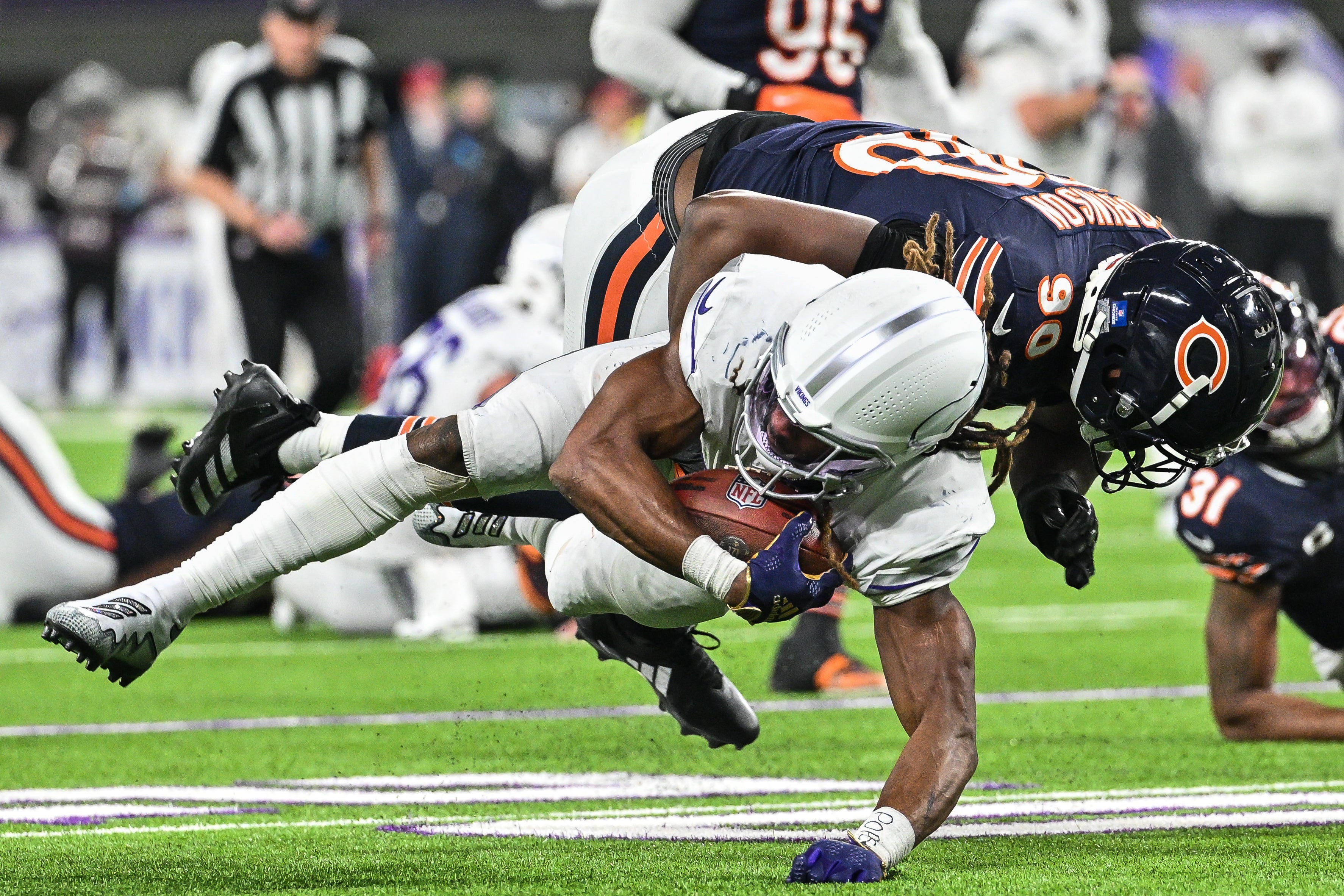Dec 16, 2024; Minneapolis, Minnesota, USA; Minnesota Vikings running back Aaron Jones (33) is tackled by Chicago Bears defensive end Dominique Robinson (90) during the third quarter at U.S. Bank Stadium.