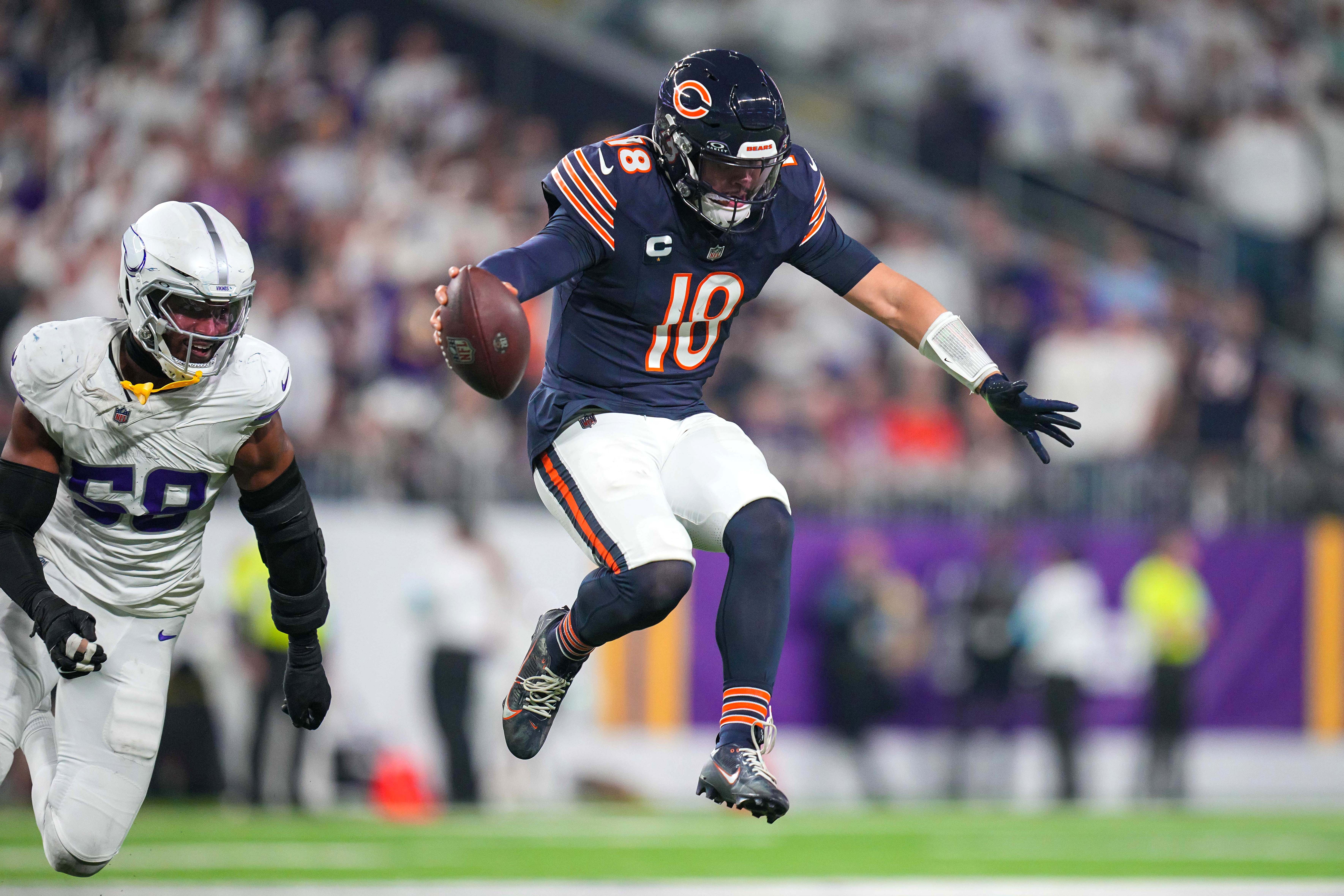 Dec 16, 2024; Minneapolis, Minnesota, USA; Chicago Bears quarterback Caleb Williams (18) scrambles against the Minnesota Vikings in the fourth quarter at U.S. Bank Stadium.