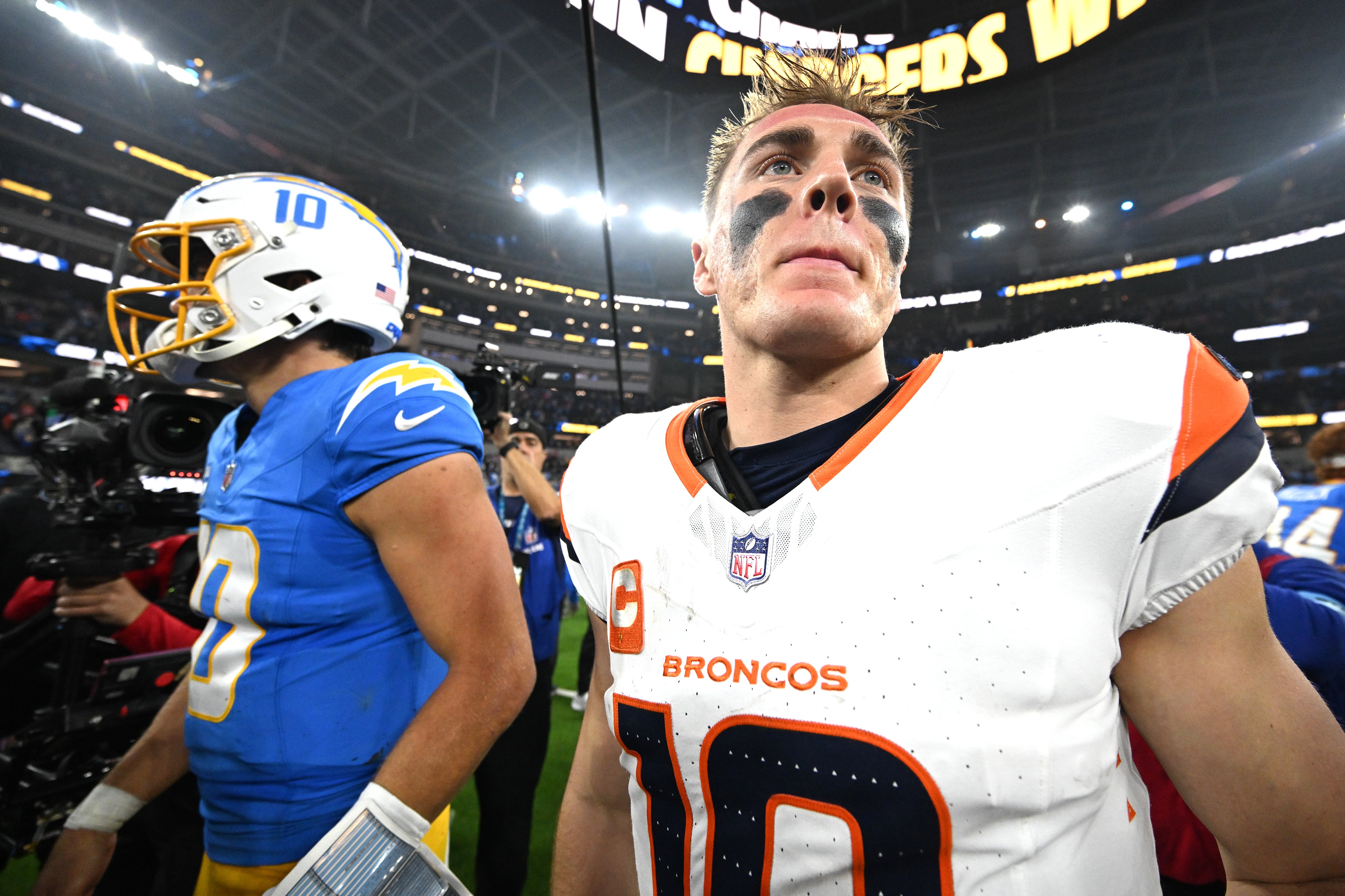 Dec 19, 2024; Inglewood, California, USA; Los Angeles Chargers quarterback Justin Herbert (10) and Denver Broncos quarterback Bo Nix (10) embrace following the game at SoFi Stadium.