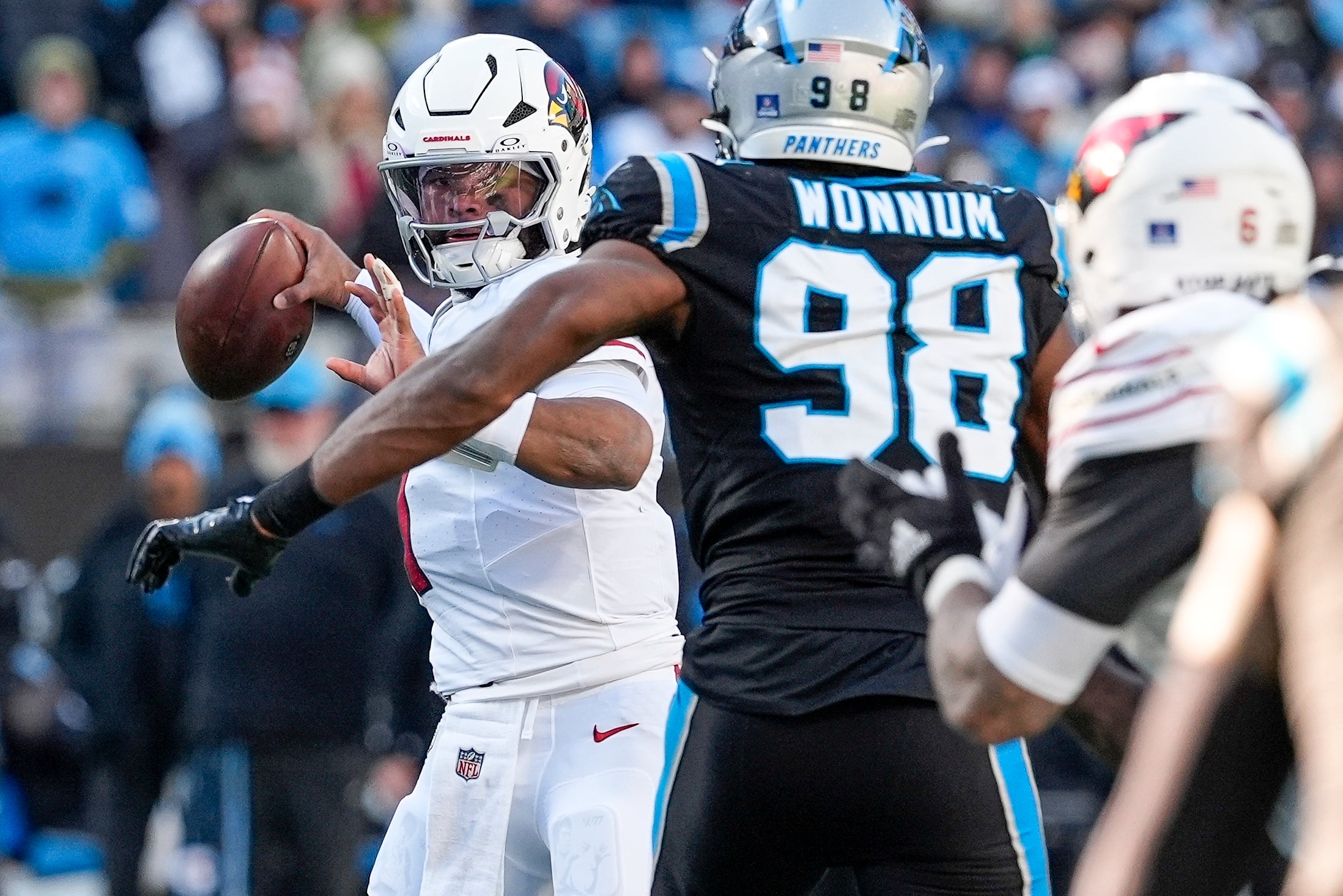Dec 22, 2024; Charlotte, North Carolina, USA; Arizona Cardinals quarterback Kyler Murray (1) looks to pass under pressure from Carolina Panthers linebacker D.J. Wonnum (98) during the second half at Bank of America Stadium.