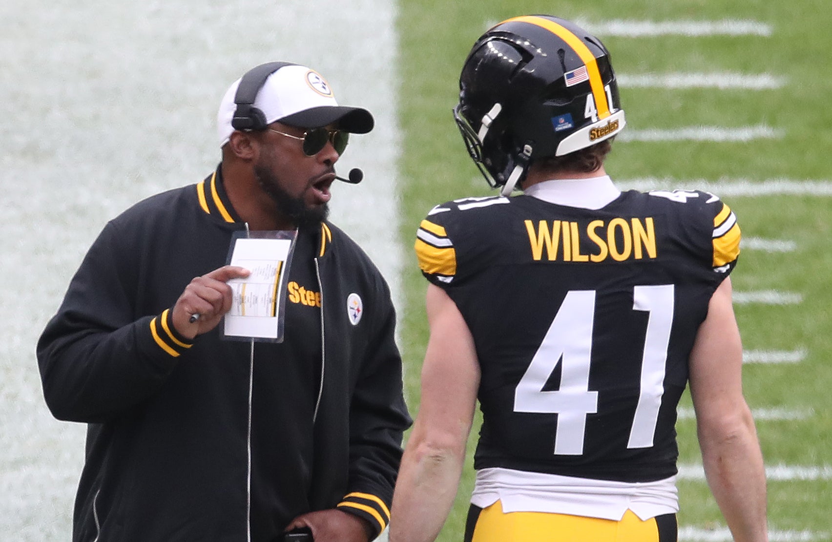 Dec 25, 2024; Pittsburgh, Pennsylvania, USA; Pittsburgh Steelers head coach Mike Tomlin (left) talks with linebacker Payton Wilson (41) on the sidelines against the Kansas City Chiefs during the third quarter at Acrisure Stadium.