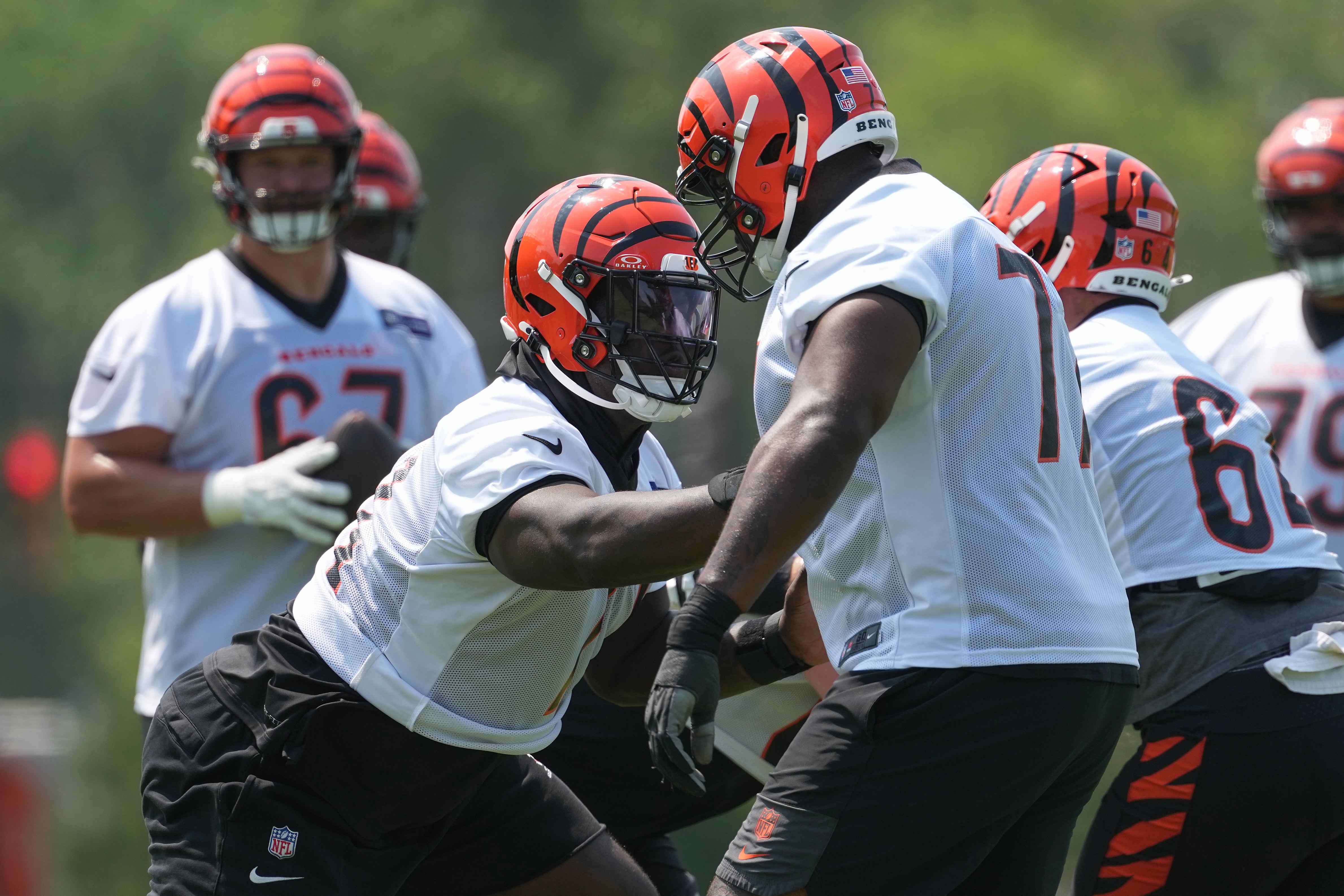 Jun 10, 2025; Cincinnati, OH, USA; Cincinnati Bengals offensive tackle Amarius Mims (71) (left) blocks offensive tackle Caleb Etienne (77) (right) during practice at Paycor Stadium.