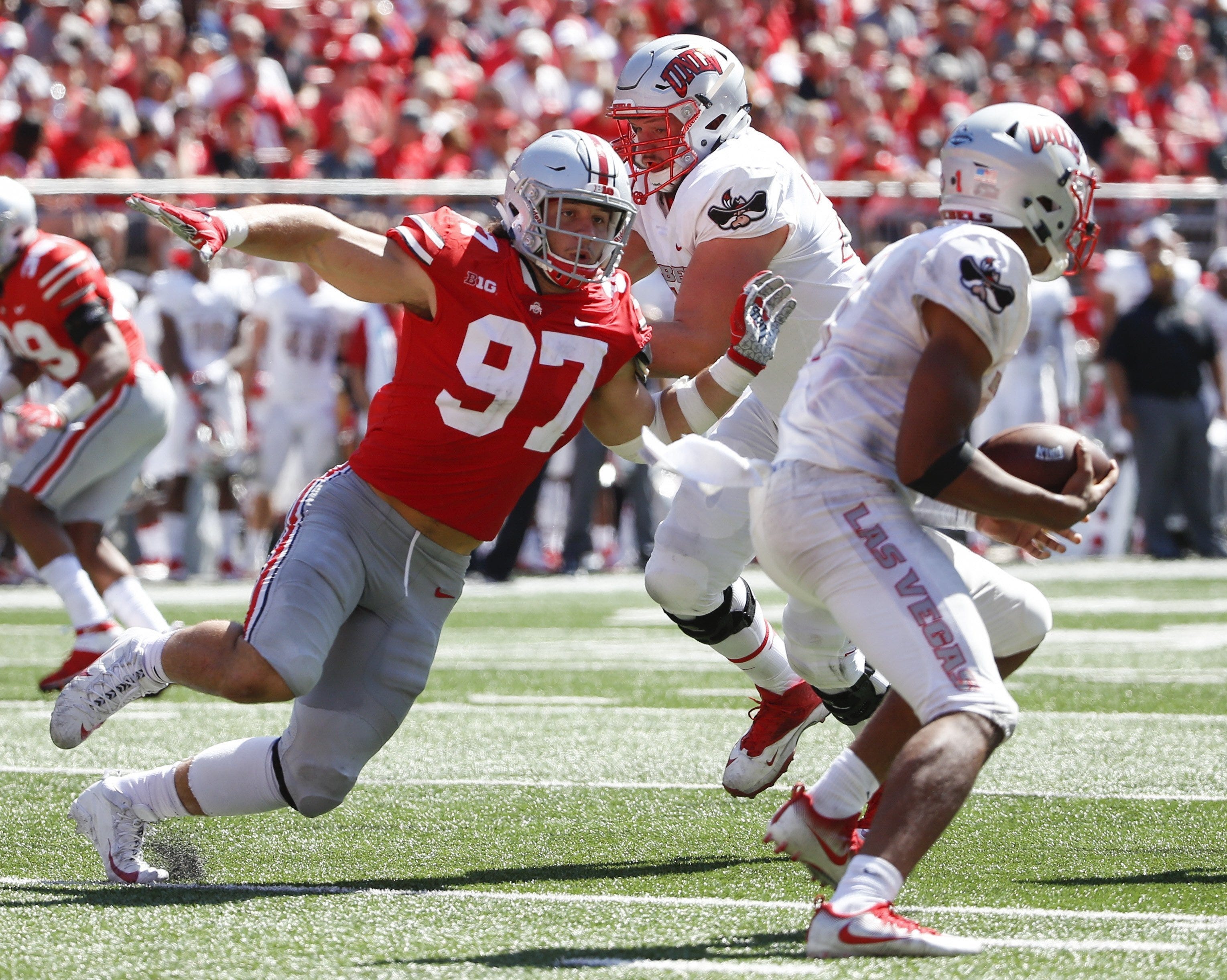 Ohio State Buckeyes defensive lineman Nick Bosa (97) chases down UNLV Rebels quarterback Armani Rogers (1) under pressure from UNLV Rebels offensive lineman Kyle Saxelid, center, during the second quarter of a NCAA college football game between the Ohio State Buckeyes and the UNLV Rebels on Saturday, September 23, 2017 at Ohio Stadium in Columbus, Ohio. [Joshua A. Bickel/Dispatch]
