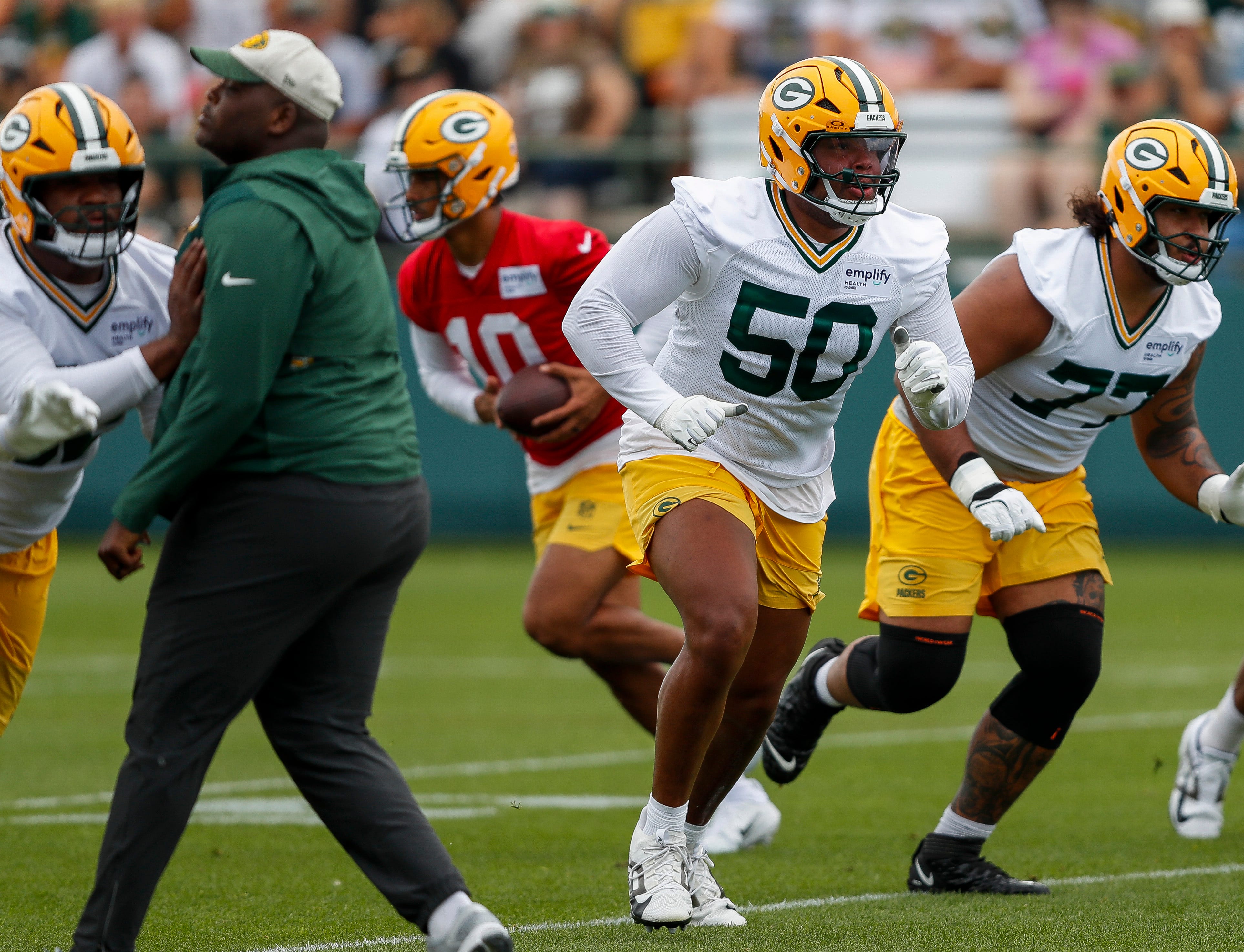 Green Bay Packers offensive tackle Zach Tom (50) runs through a drill during the first day of training camp on Wednesday, July 23, 2025, at Ray Nitschke Field in Ashwaubenon, Wis.