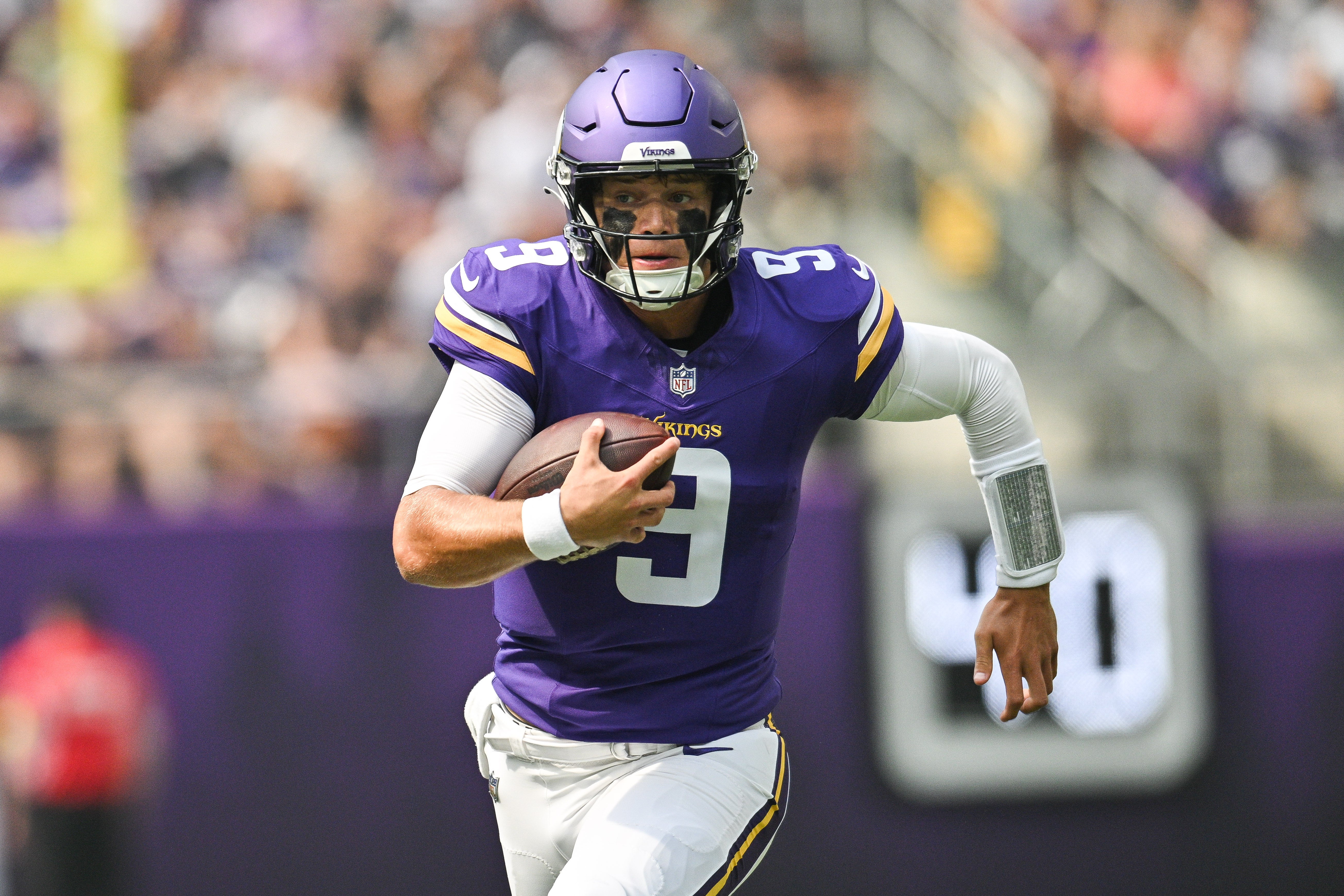 Aug 9, 2025; Minneapolis, Minnesota, USA; Minnesota Vikings quarterback J.J. McCarthy (9) scrambles for a gain against the Houston Texans during the first quarter at U.S. Bank Stadium.