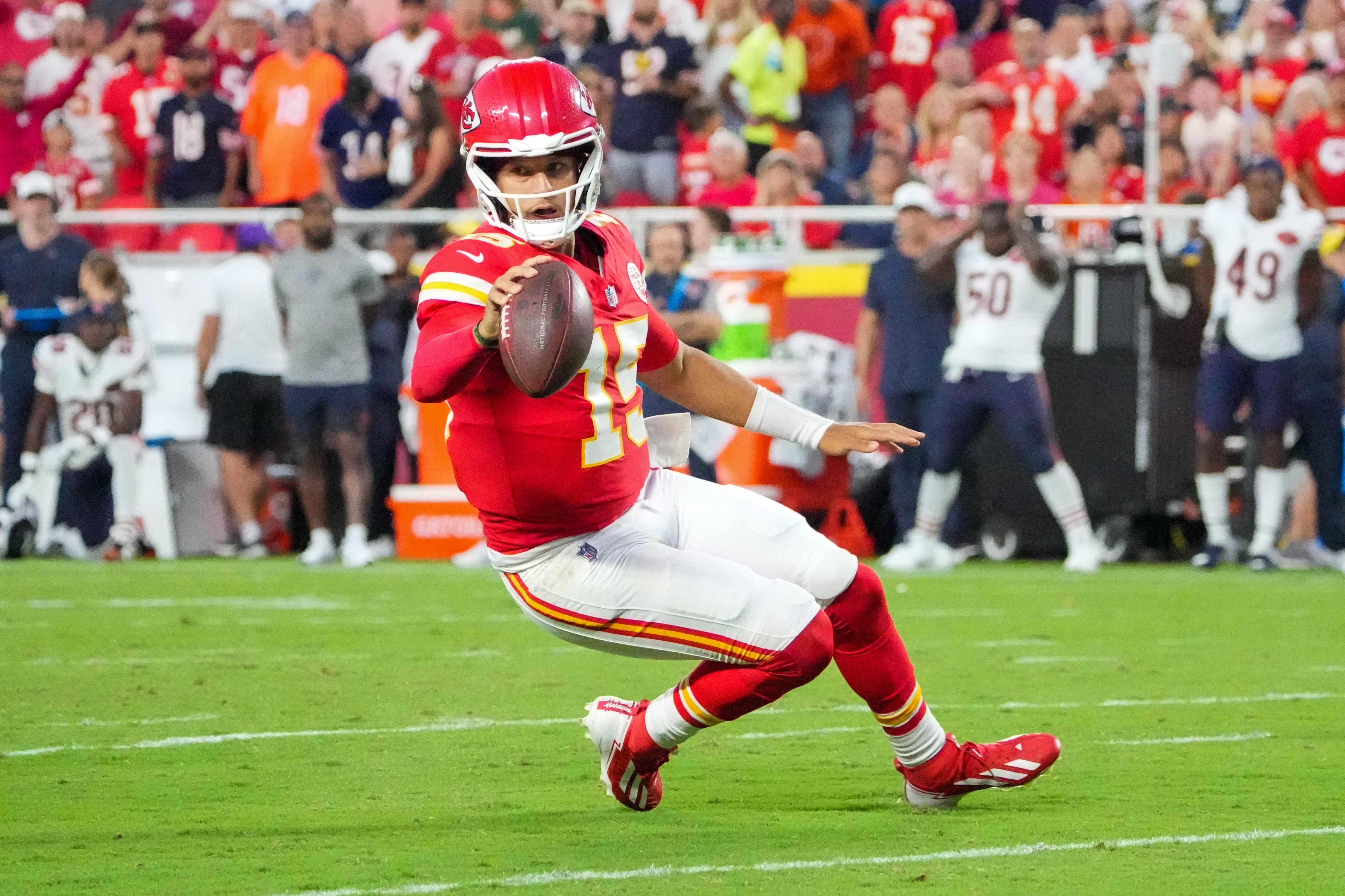 Aug 22, 2025; Kansas City, Missouri, USA; Kansas City Chiefs quarterback Patrick Mahomes (15) runs for a first down against the Chicago Bears during the first half of the game at GEHA Field at Arrowhead Stadium.