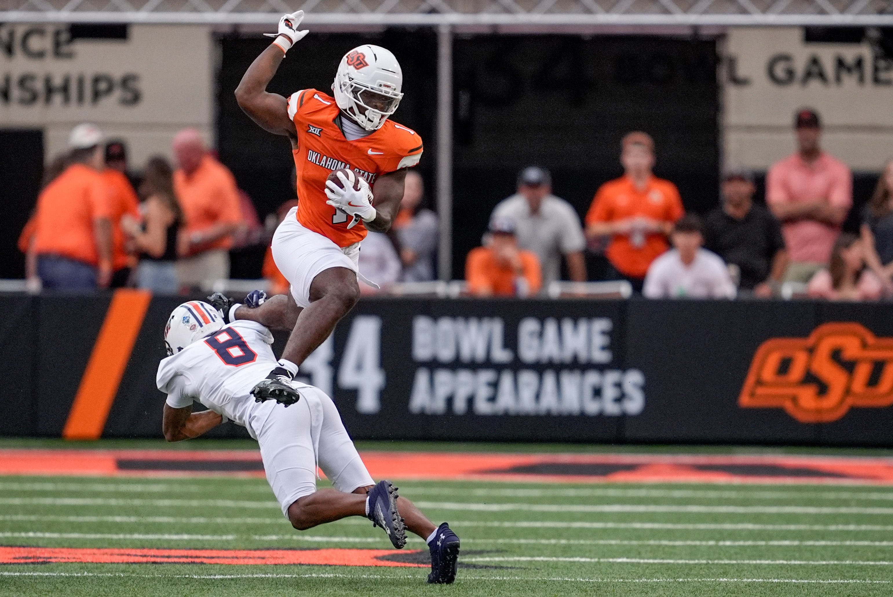 Oklahoma State running back Kalib Hicks (1) hurdles over Tennessee Martin cornerback JaMichael McGoy Jr. (8) in the first quarter during an NCAA football game between Oklahoma State (OSU) and UT Martin in Stillwater, Okla., on Thursday, Aug. 28, 2025.