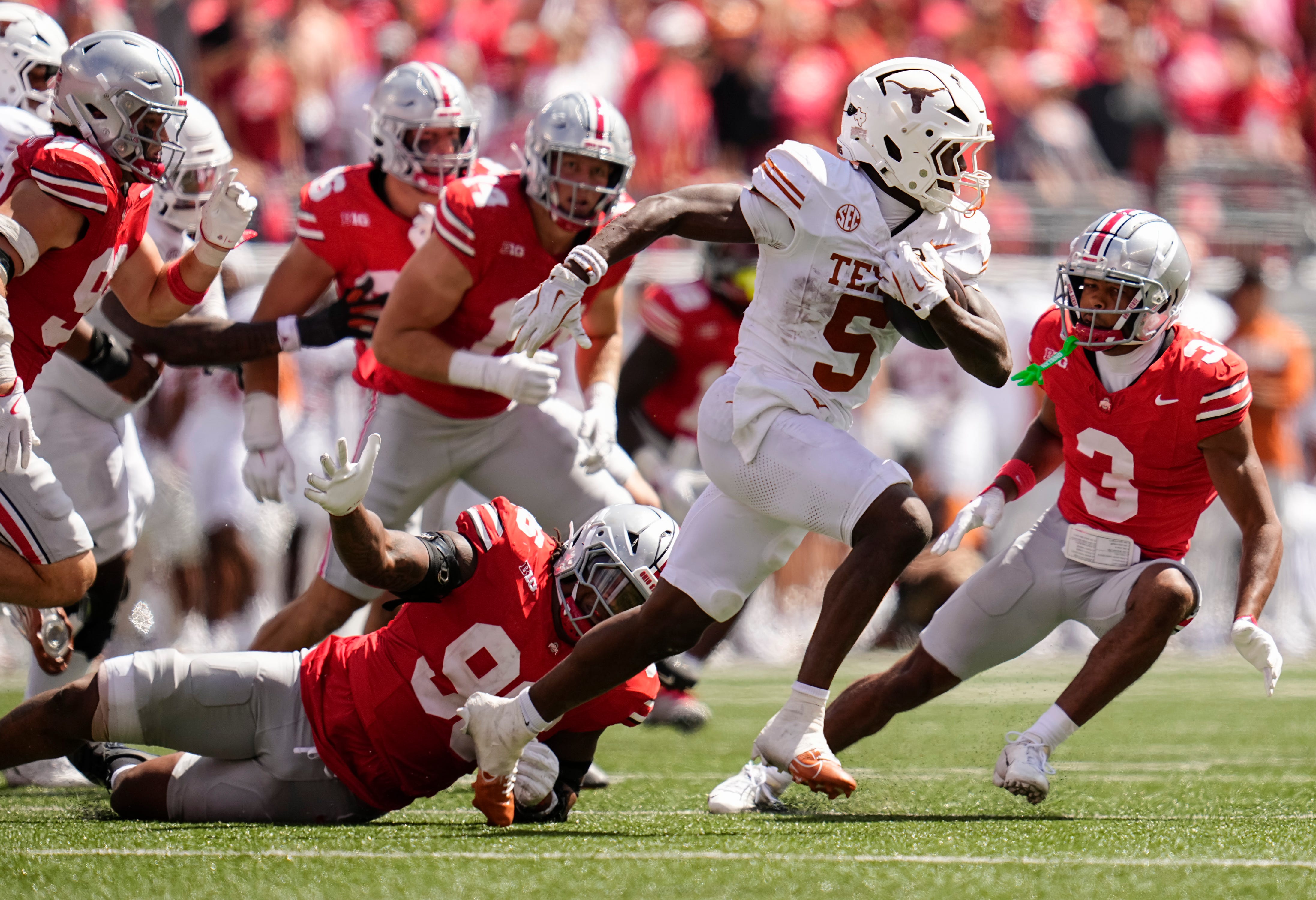 Texas Longhorns running back Quintrevion Wisner (5) runs past Ohio State Buckeyes defensive end Eddrick Houston (96) during the second half of the NCAA football game at Ohio Stadium on Aug. 30, 2025. Ohio State won 14-7.