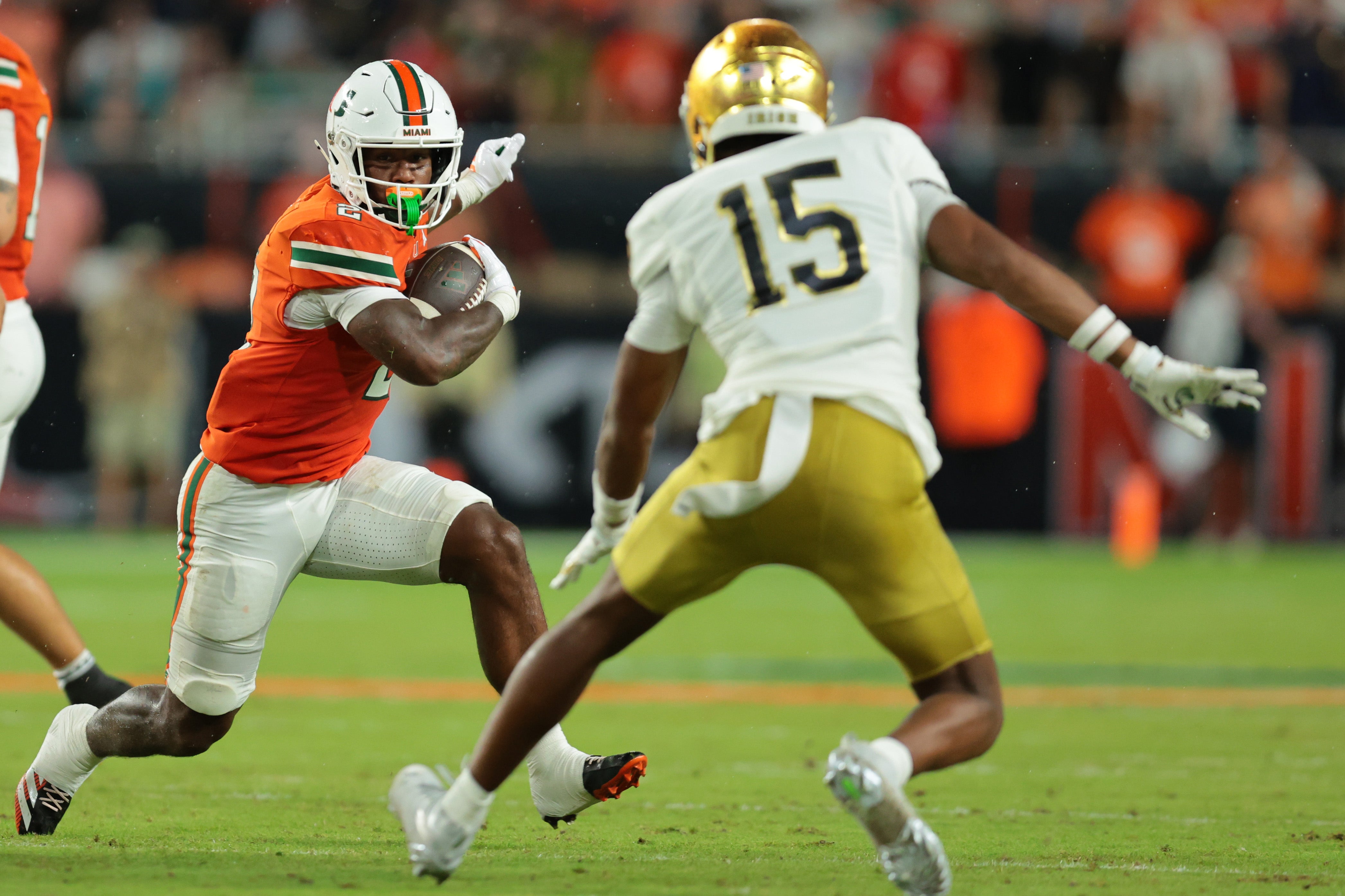 Aug 31, 2025; Miami Gardens, Florida, USA; Miami Hurricanes running back Jordan Lyle (2) rushes the ball against Notre Dame Fighting Irish cornerback Leonard Moore (15) during the second quarter at Hard Rock Stadium. Mandatory Credit: Sam Navarro-Imagn Images