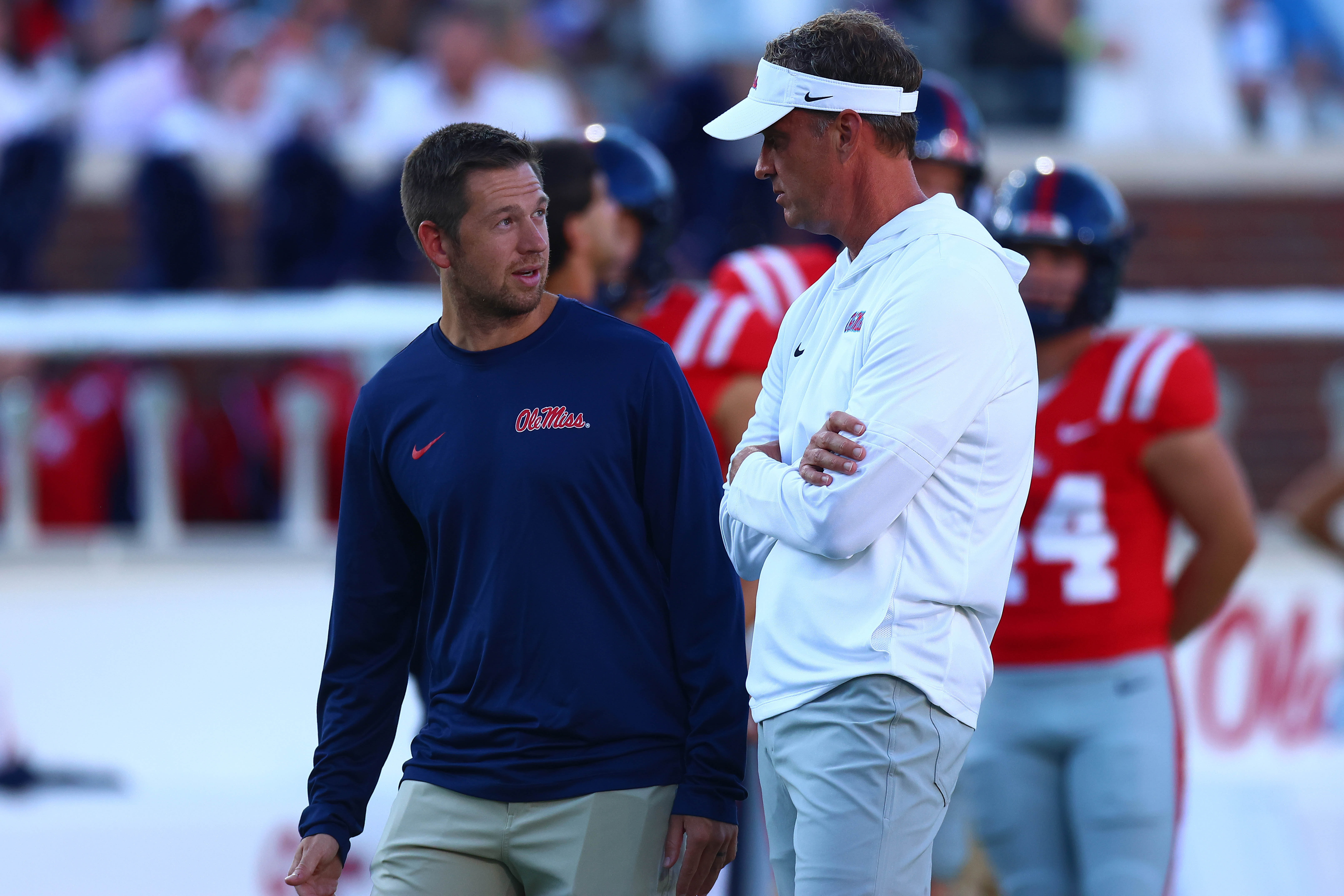 Aug 30, 2025; Oxford, Mississippi, USA; Mississippi Rebels head coach Lane Kiffin (right) talks with offensive coordinator Charlie Weis Jr. during warm ups prior to the game against the Georgia State Panthers at Vaught-Hemingway Stadium.
