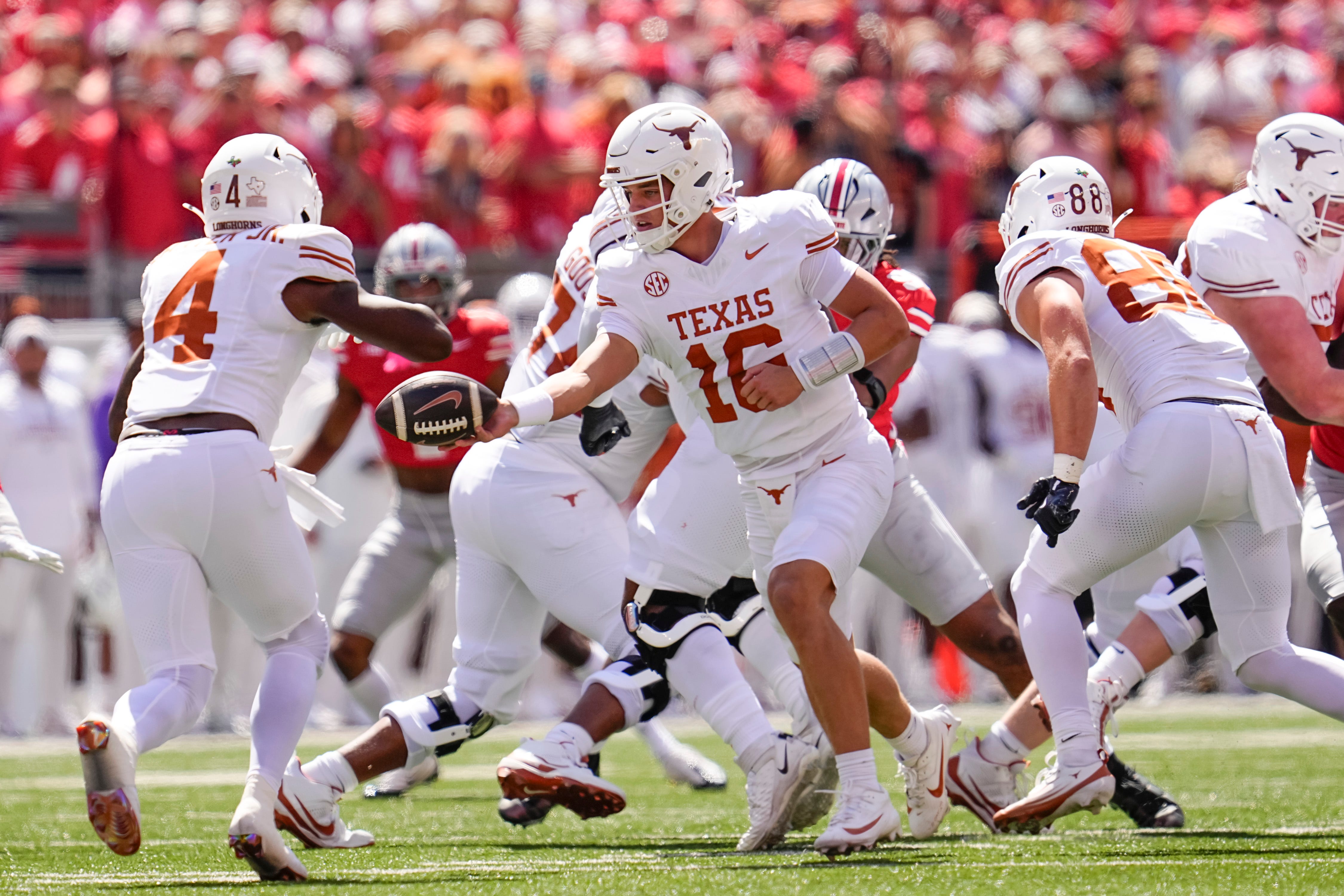Texas Longhorns quarterback Arch Manning (16) hands off to running back CJ Baxter (4) during the NCAA football game against the Ohio State Buckeyes at Ohio Stadium on Aug. 30, 2025.