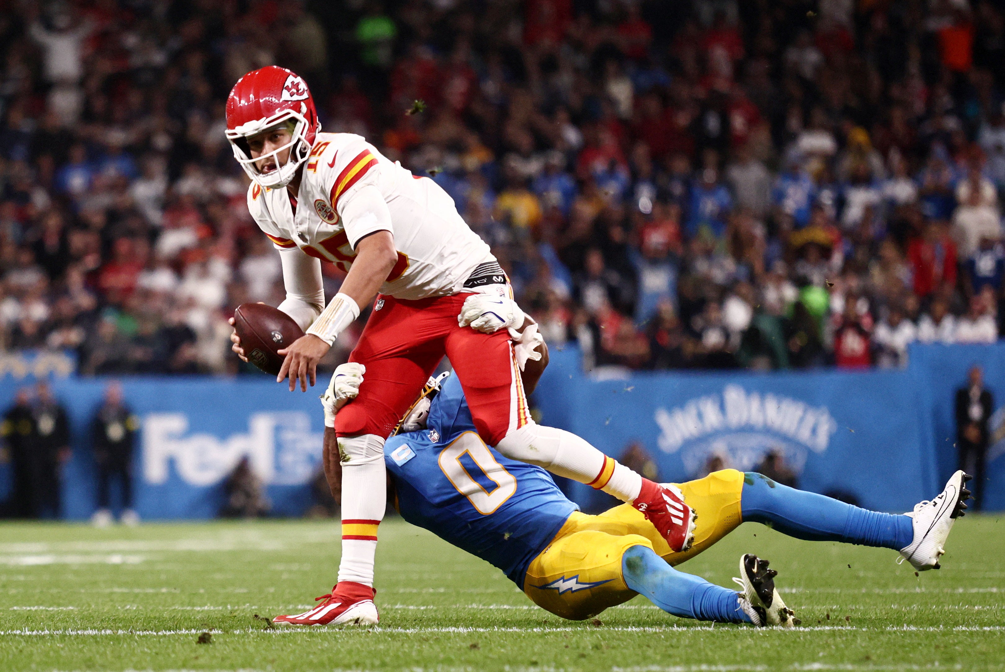Kansas City Chiefs quarterback Patrick Mahomes (15) runs against Los Angeles Chargers linebacker Daiyan Henley (0) in the first half during a NFL game at Corinthians Arena.