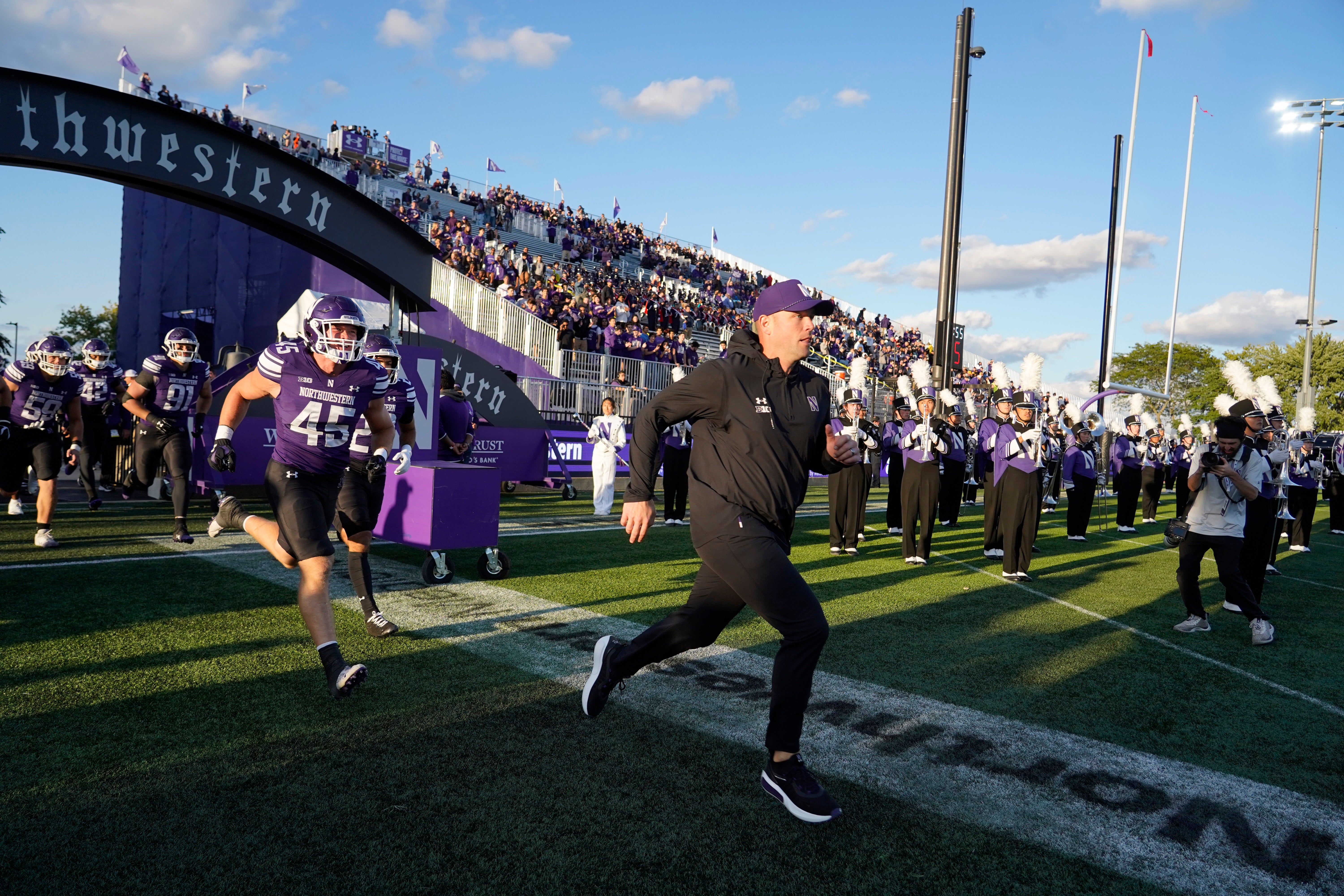 Sep 5, 2025; Evanston, Illinois, USA; Northwestern Wildcats head coach David Braun takes the field with his team against the Western Illinois Leathernecks at Northwestern Medicine Field at Martin Stadium. Mandatory Credit: David Banks-Imagn Images
