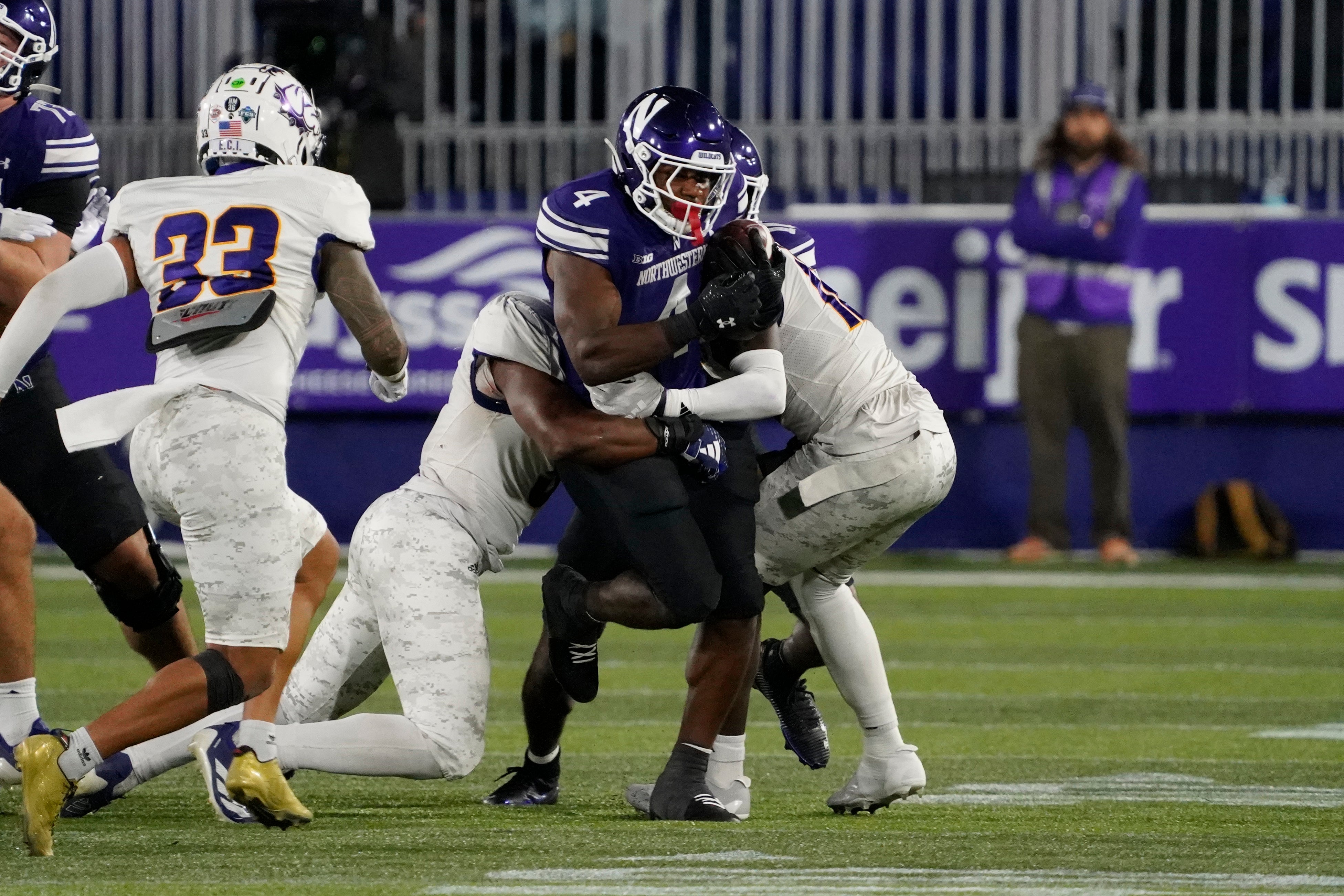 Sep 5, 2025; Evanston, Illinois, USA; Northwestern Wildcats running back Cam Porter (4) runs against the Western Illinois Leathernecks during the second half at Northwestern Medicine Field at Martin Stadium. Mandatory Credit: David Banks-Imagn Images