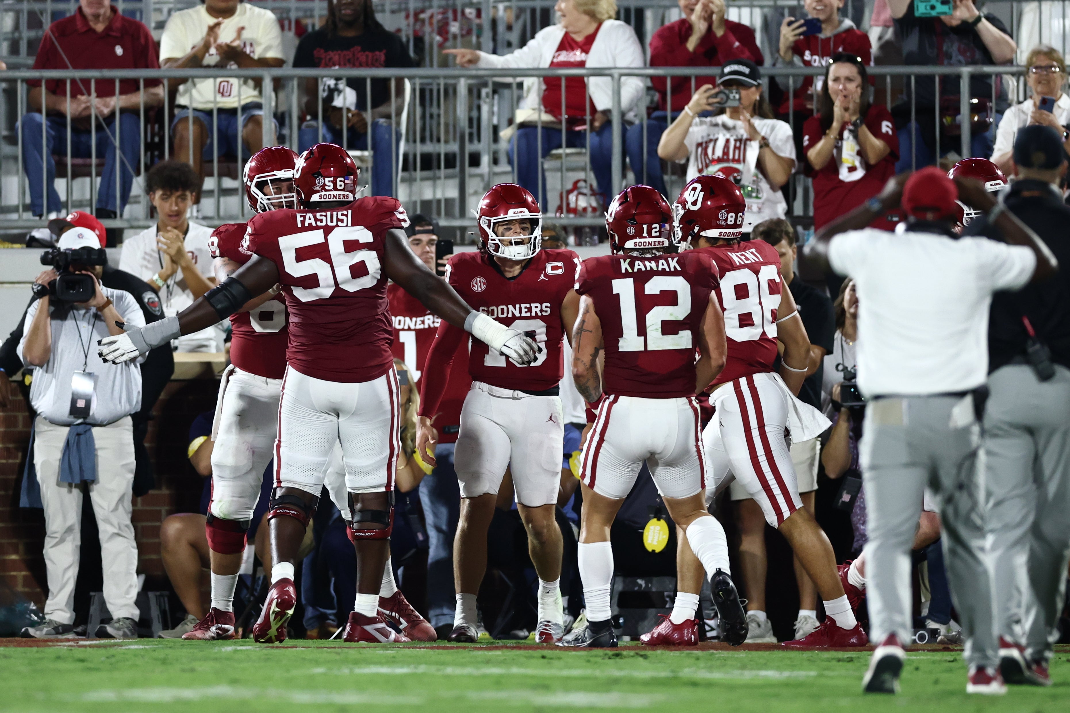 Sep 6, 2025; Norman, Oklahoma, USA; Oklahoma Sooners quarterback John Mateer (10) celebrates with teammates after scoring on a touchdown run against the Michigan Wolverines during the first half at Gaylord Family-Oklahoma Memorial Stadium.