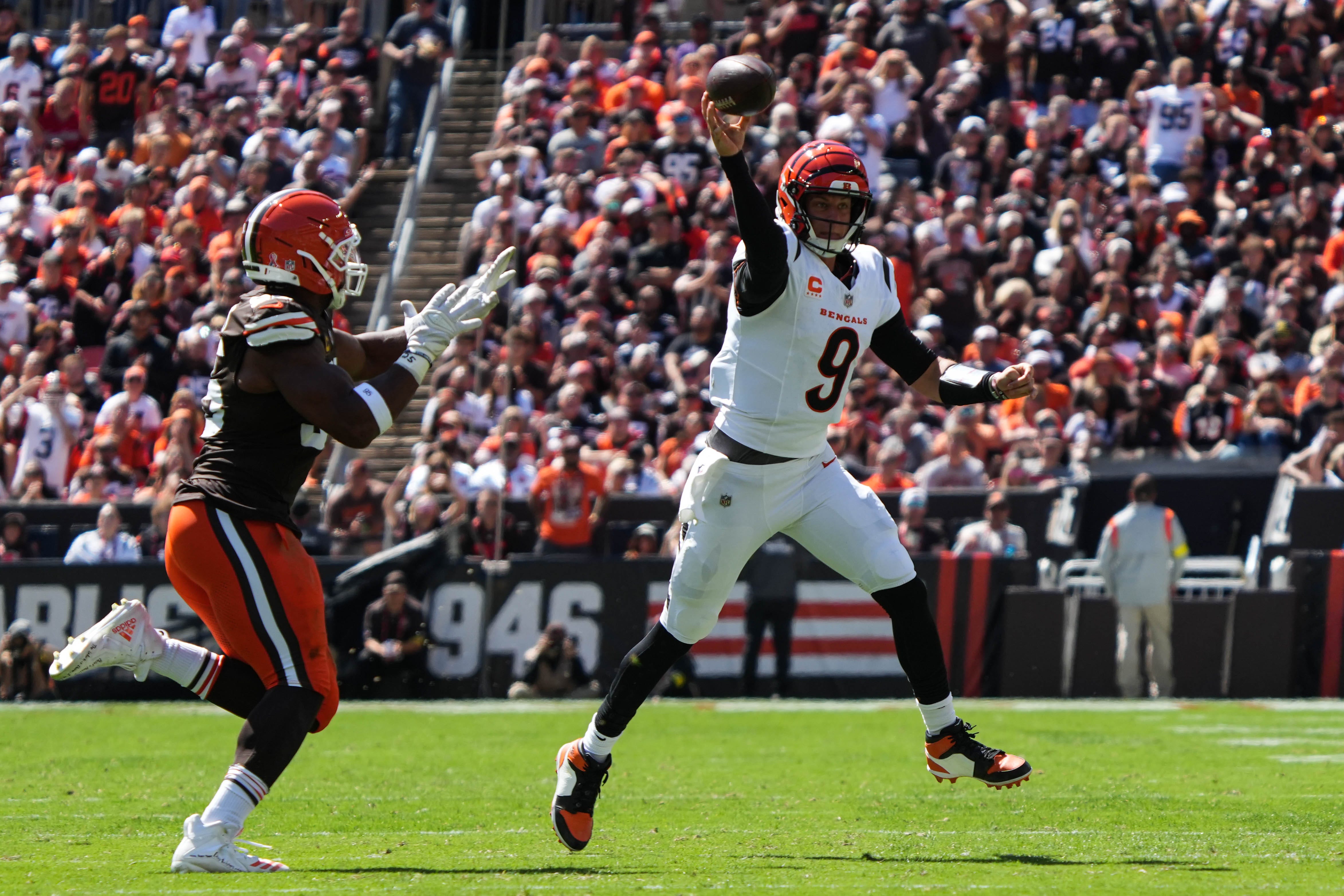 Bengals Joe Burrow (9) runs to avoid the Browns and throws during the game at Huntington Bank Field on Sunday, Sept. 7, 2025.