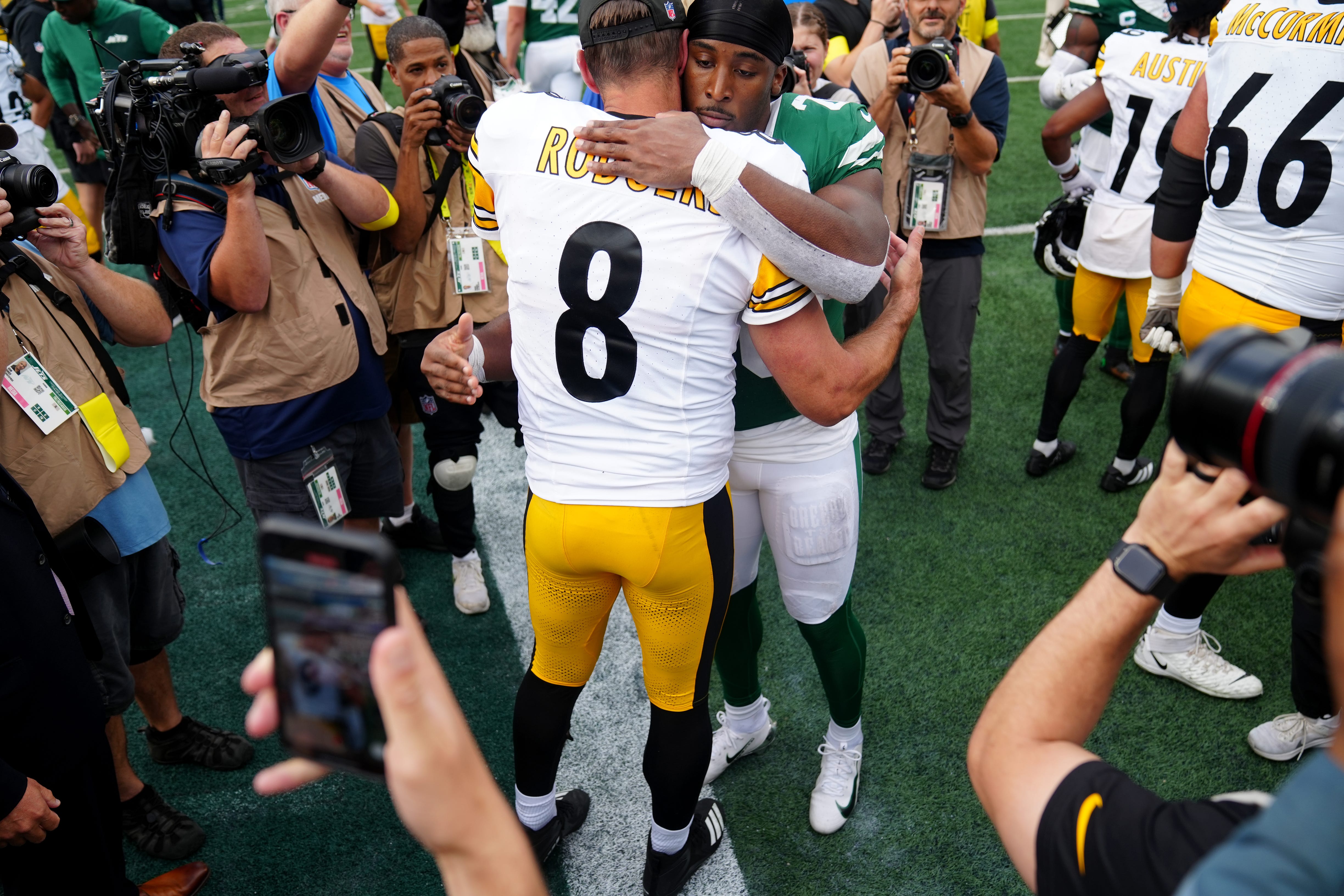 Pittsburgh Steelers quarterback Aaron Rodgers (8) and New York Jets running back Breece Hall (20) share a hug after the game, Sunday, September 7, 2025, in East Rutherford.