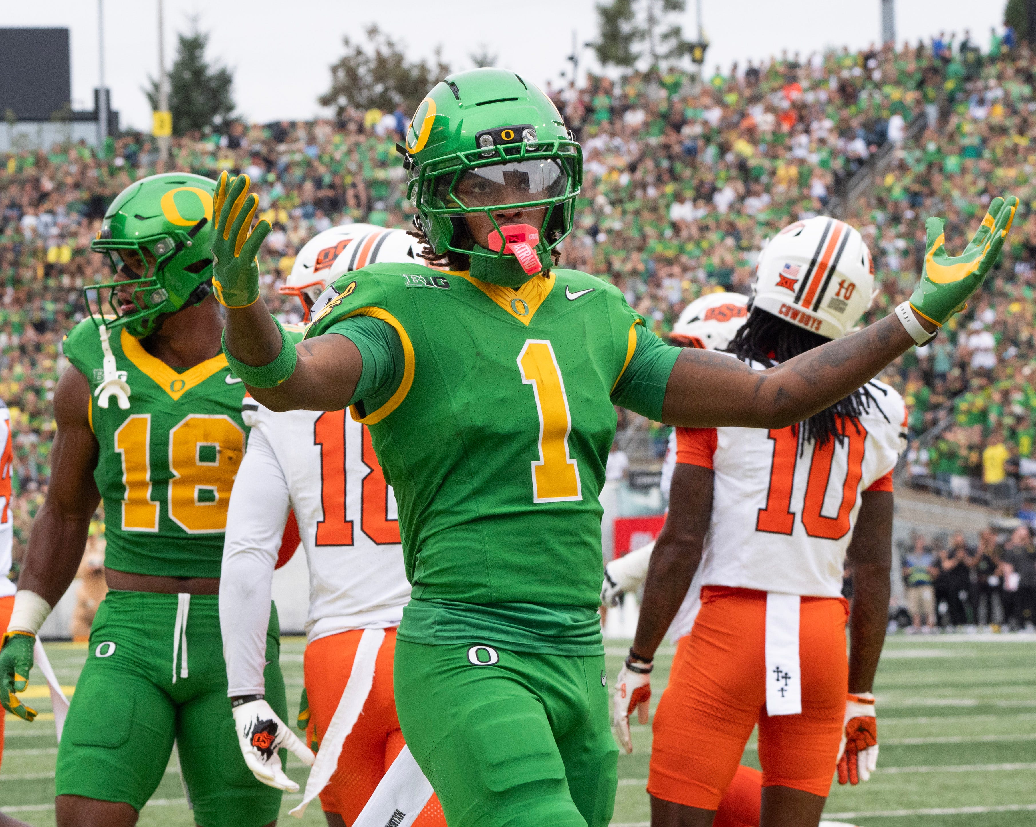 Oregon’s Dakorien Moore celebrates with Duck fans during the game against Oklahoma State.