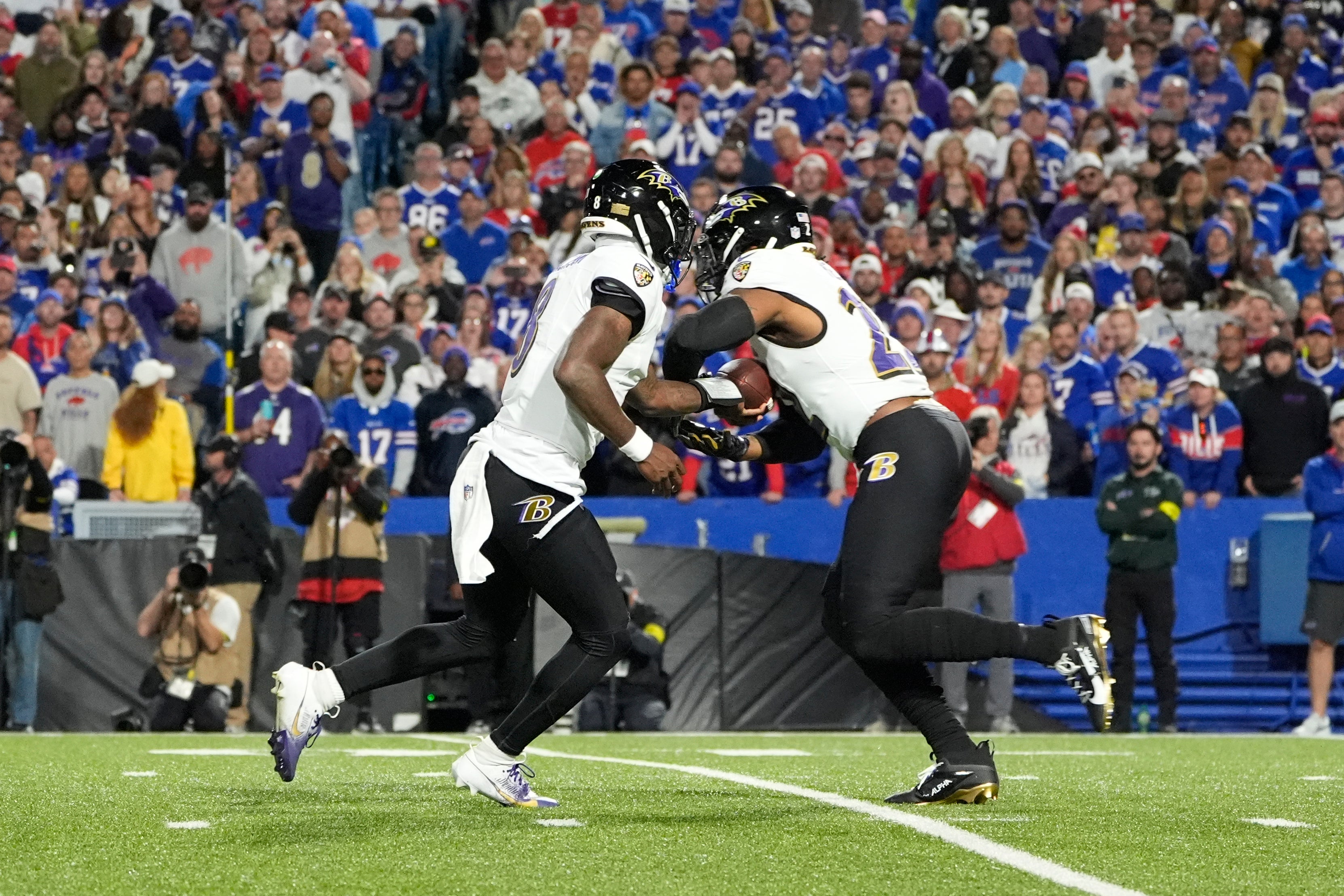 Sep 7, 2025; Orchard Park, New York, USA; Baltimore Ravens quarterback Lamar Jackson (8) hands off the ball to running back Derrick Henry (22) during the second quarter against the Buffalo Bills at Highmark Stadium.