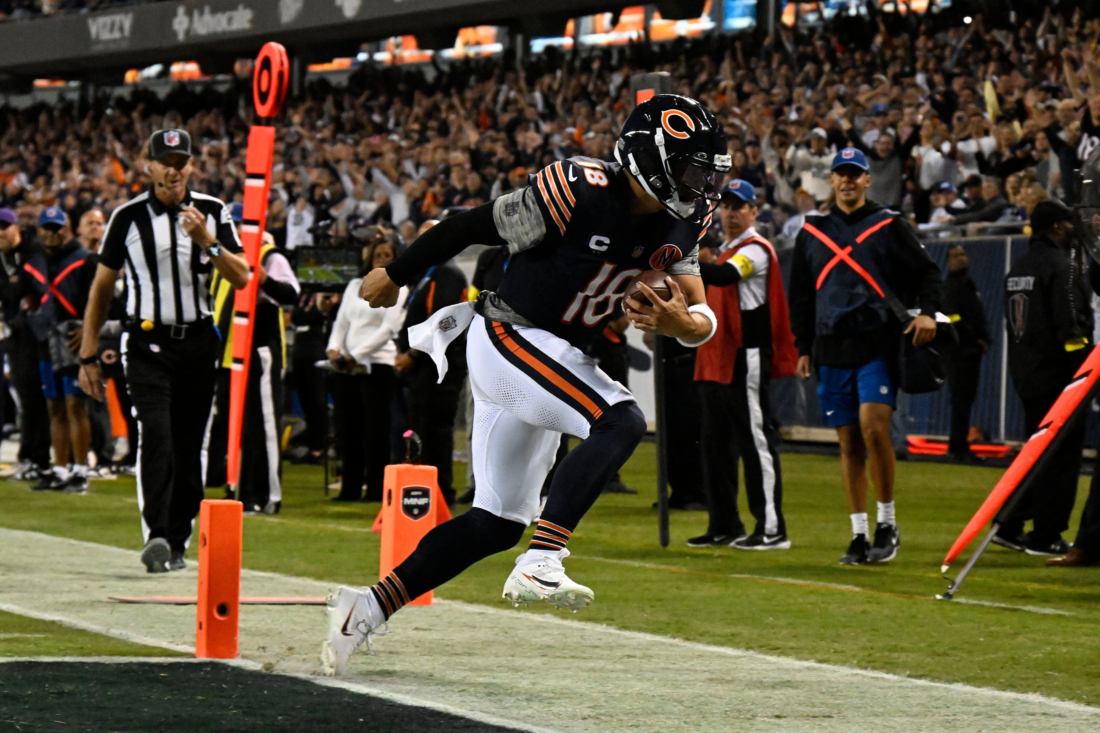 Sep 8, 2025; Chicago, Illinois, USA; Chicago Bears quarterback Caleb Williams (18) rushes for a touchdown against the Minnesota Vikings during the first half at Soldier Field.