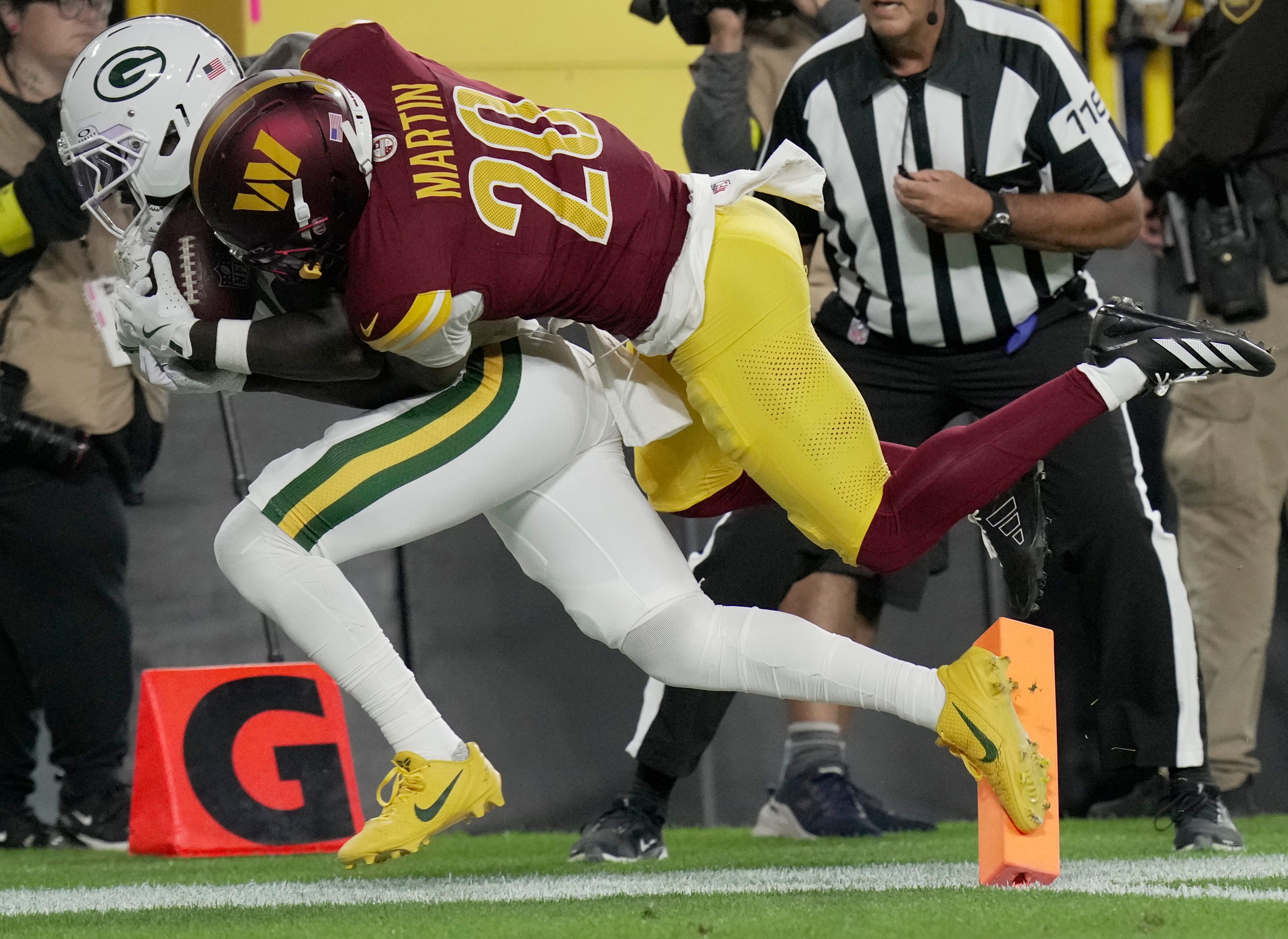 Green Bay Packers wide receiver Jayden Reed (11) is injured while being tackled by Washington Commanders safety Quan Martin (20) during the first quarter of their game Thursday, September 11, 2025 at Lambeau Field in Green Bay, Wisconsin.
