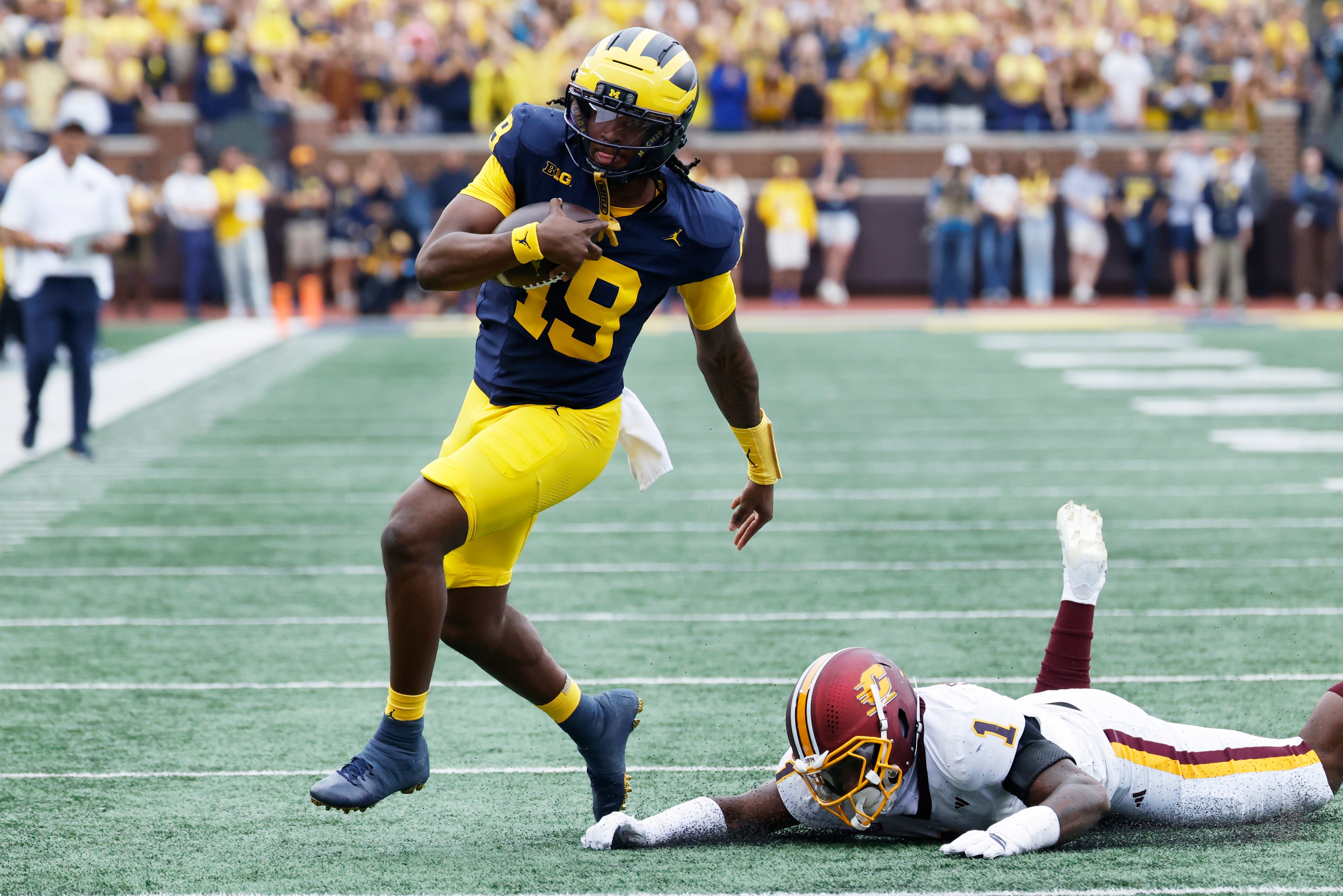 Sep 13, 2025; Ann Arbor, Michigan, USA; Michigan Wolverines quarterback Bryce Underwood (19) rushes past Central Michigan Chippewas linebacker Dakota Cochran (1) in the first half at Michigan Stadium.