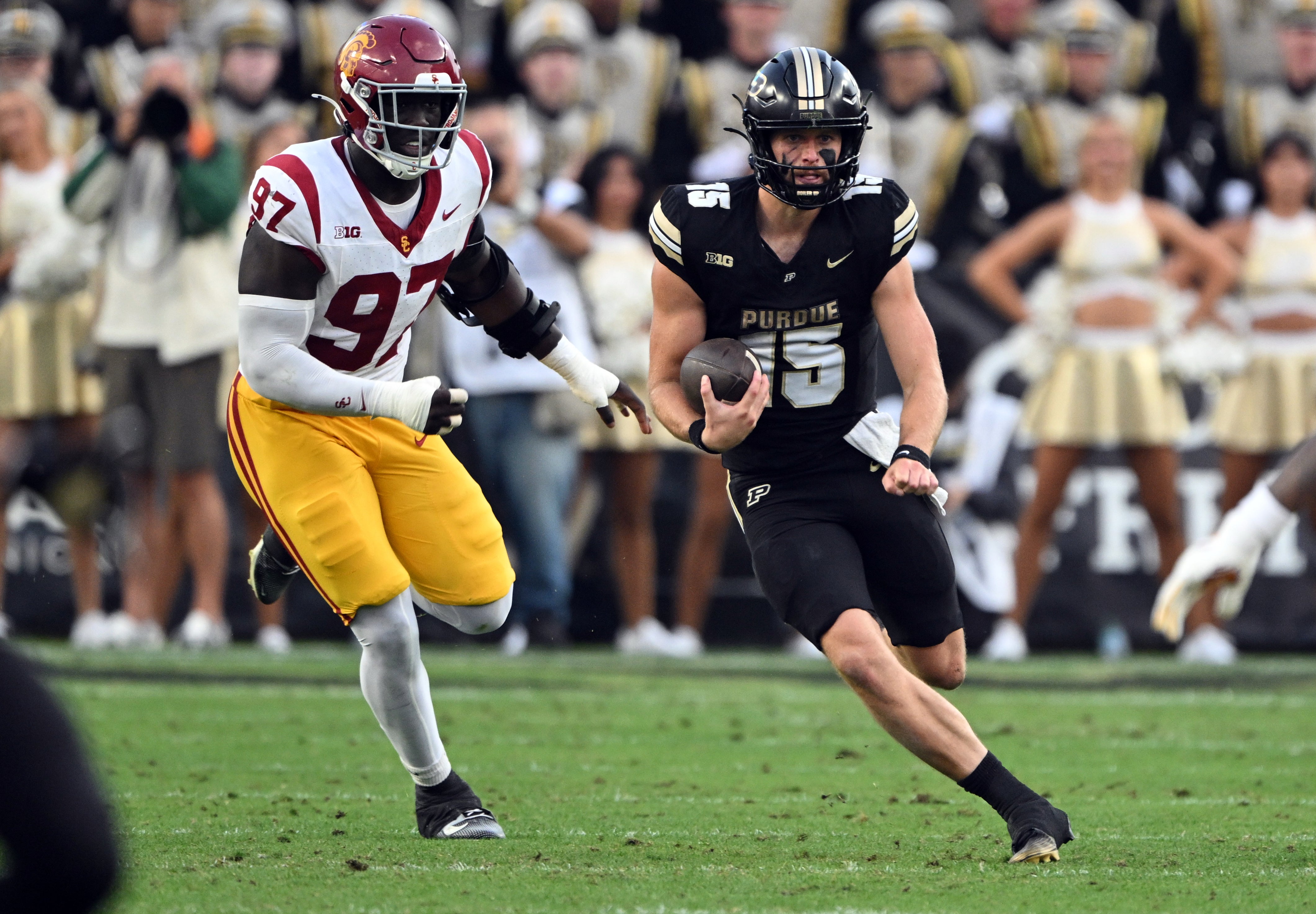Sep 13, 2025; West Lafayette, Indiana, USA; Purdue Boilermakers quarterback Ryan Browne (15) is chased by USC Trojans defensive tackle Jide Abasiri (97) during the first quarter at Ross-Ade Stadium. Mandatory Credit: Marc Lebryk-Imagn Images