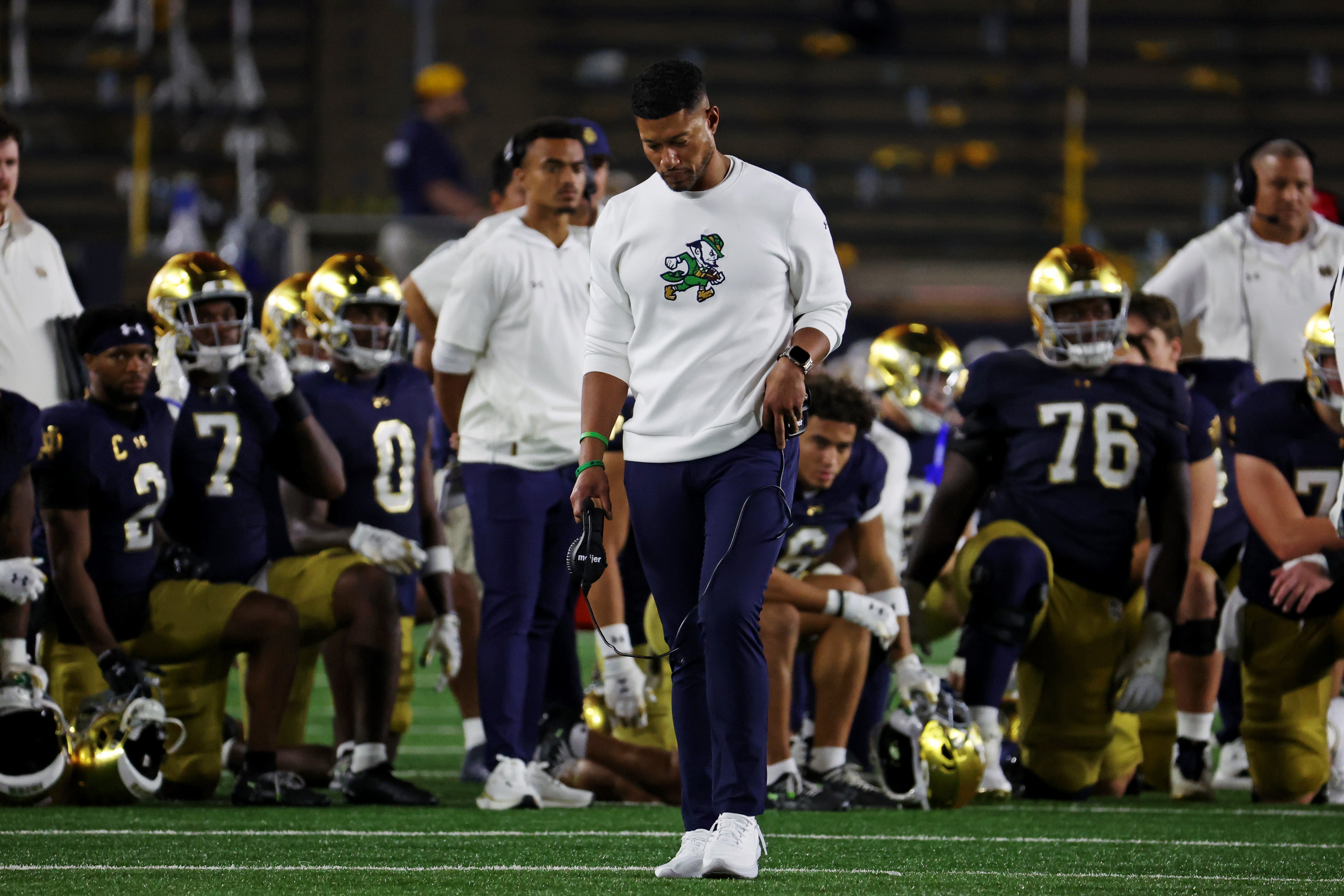 Sep 13, 2025; South Bend, Indiana, USA; Notre Dame Fighting Irish head coach Marcus Freeman looks on as the team takes a knee for Notre Dame Fighting Irish tight end Eli Raridon (9) after an apparent injury against Texas A&M Aggies during the second half at Notre Dame Stadium. Mandatory Credit: Trevor Ruszkowski-Imagn Images