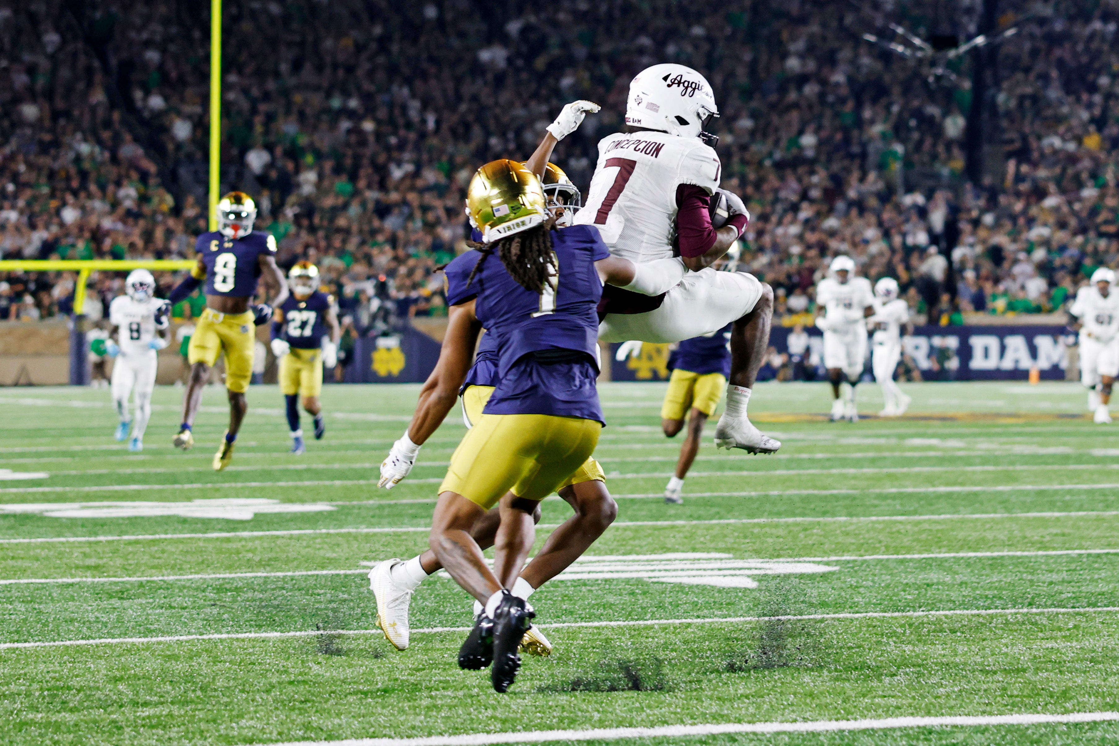 Sep 13, 2025; South Bend, Indiana, USA; Texas A&M Aggies wide receiver KC Concepcion (7) controls the ball as Notre Dame Fighting Irish safety Jalen Stroman (7) defends during the second half at Notre Dame Stadium. Mandatory Credit: Michael Caterina-Imagn Images