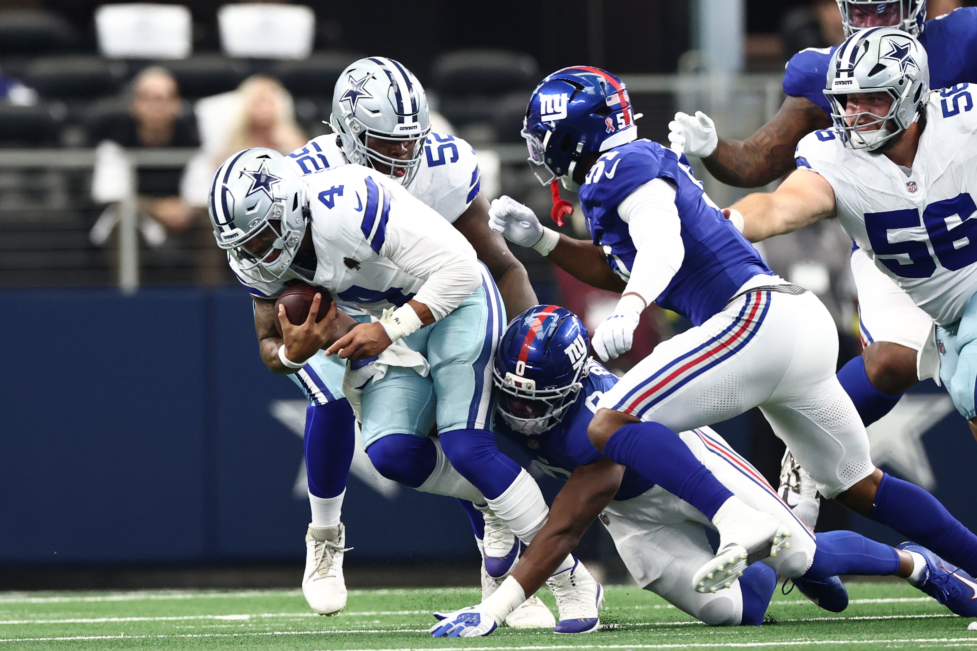 Sep 14, 2025; Arlington, Texas, USA; New York Giants linebacker Brian Burns (0) tackles Dallas Cowboys quarterback Dak Prescott (4) during the second quarter at AT&T Stadium.