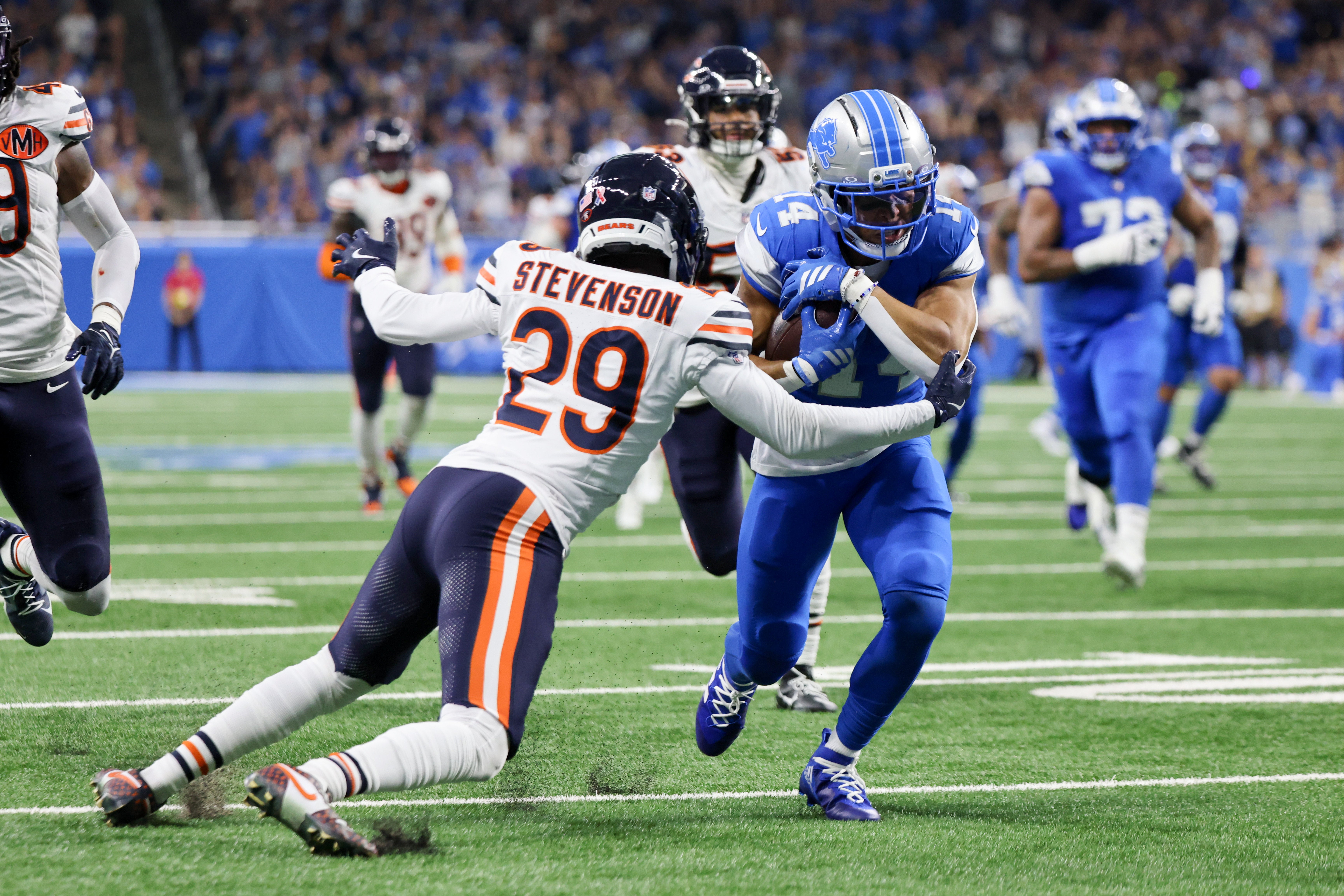 Sep 14, 2025; Detroit, Michigan, USA; Detroit Lions wide receiver Amon-Ra St. Brown (14) carries the ball defended by Chicago Bears cornerback Tyrique Stevenson (29) during the first quarter at Ford Field.