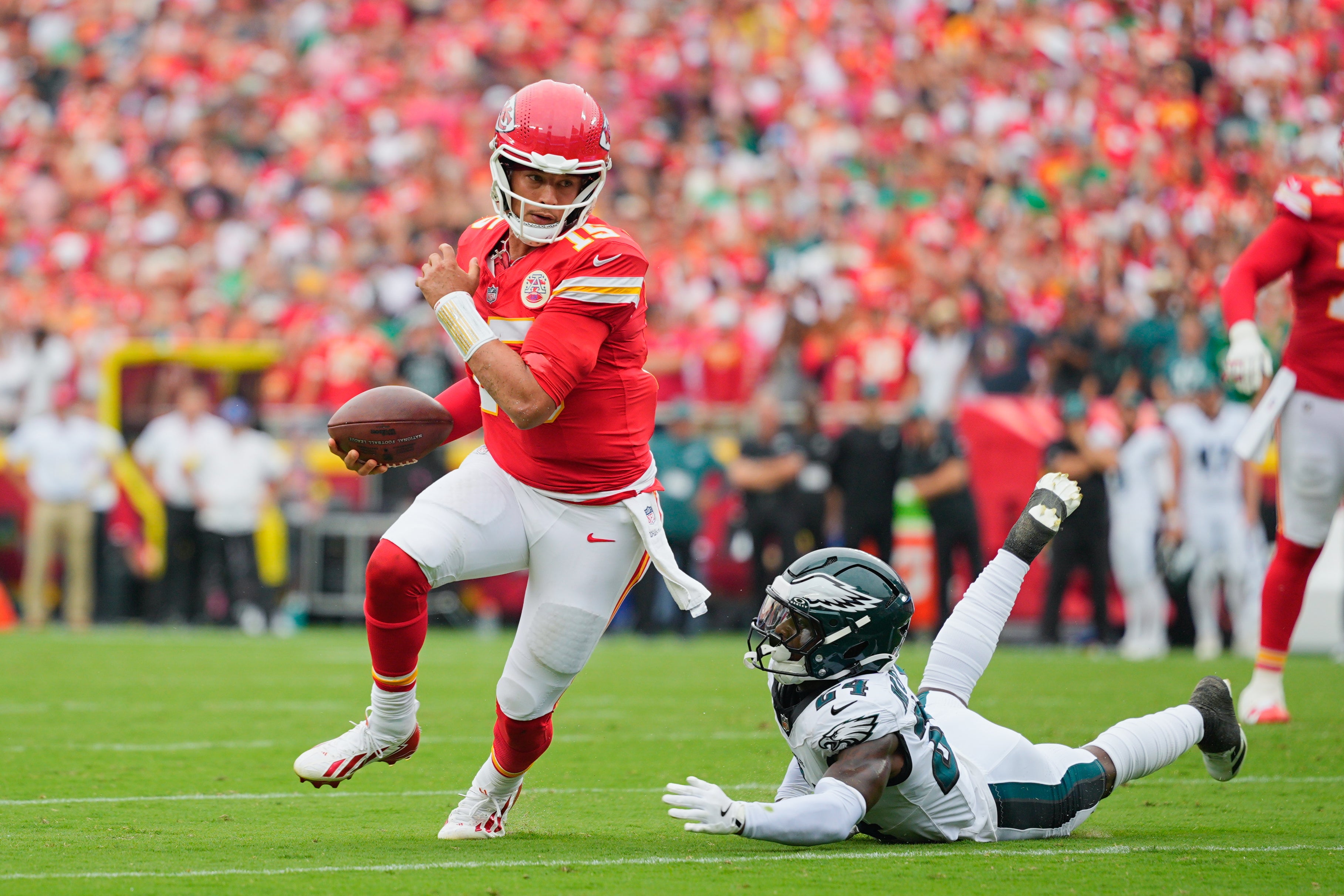 Kansas City Chiefs quarterback Patrick Mahomes (15) avoids a tackle by Philadelphia Eagles safety Andrew Mukuba (24) as he carries the ball for touchdown