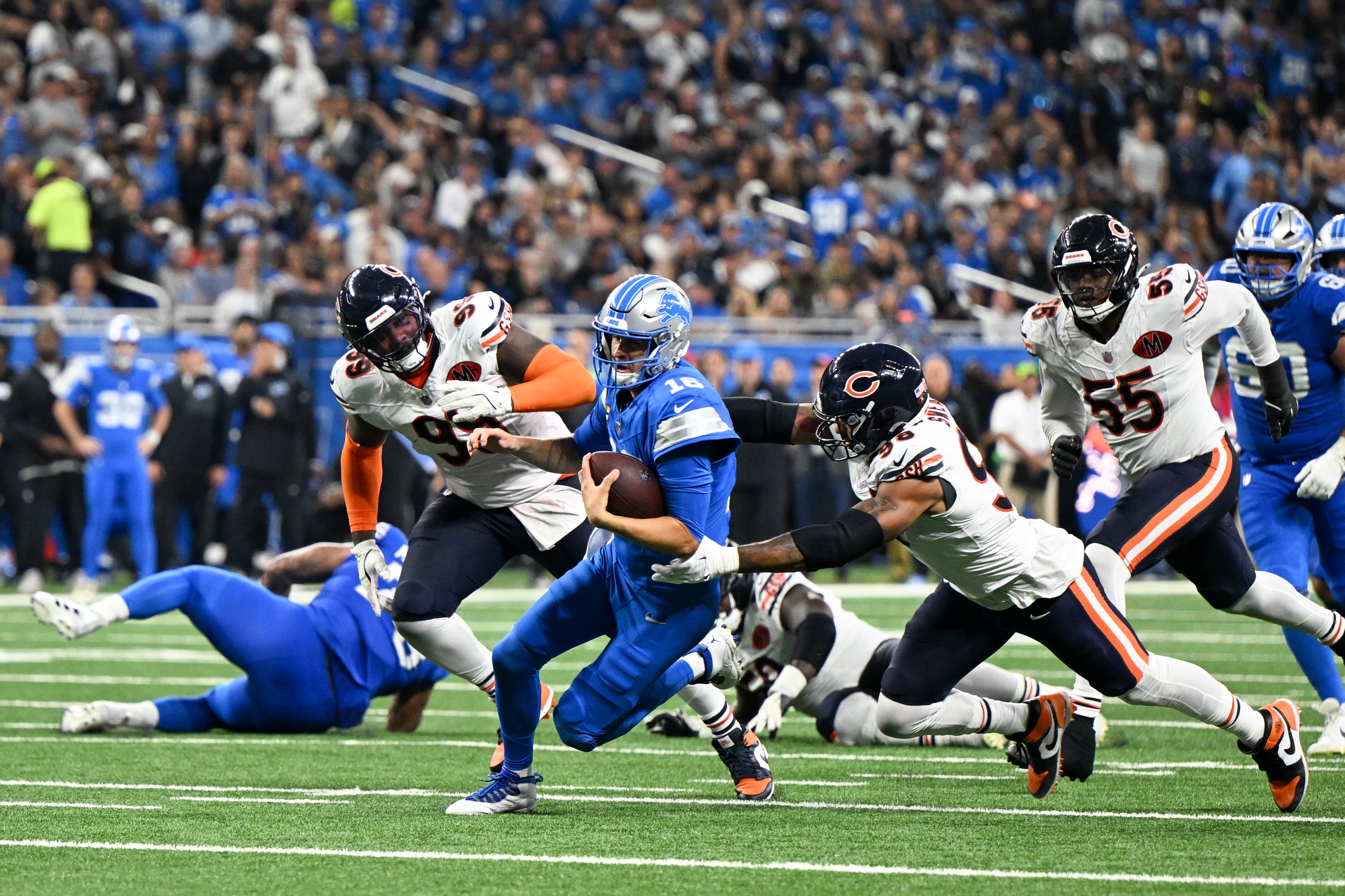 Sep 14, 2025; Detroit, Michigan, USA; Detroit Lions quarterback Jared Goff (16) scrambles with the ball defended by Chicago Bears defensive end Montez Sweat (98) during the second half of the game at Ford Field.