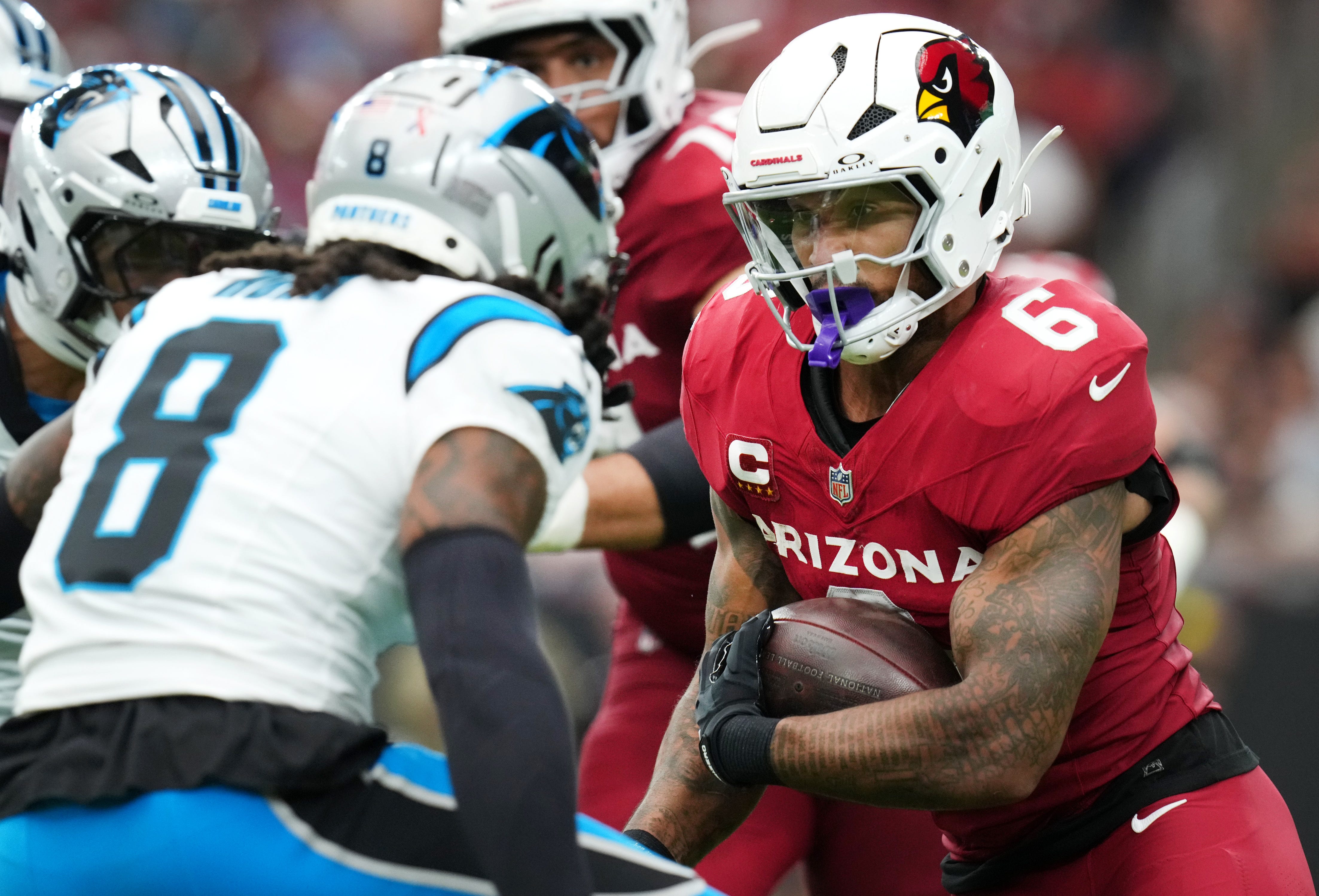 Arizona Cardinals running back James Conner (6) jukes by Carolina Panthers cornerback Jaycee Horn (8) at State Farm Stadium on Sept 14, 2025.