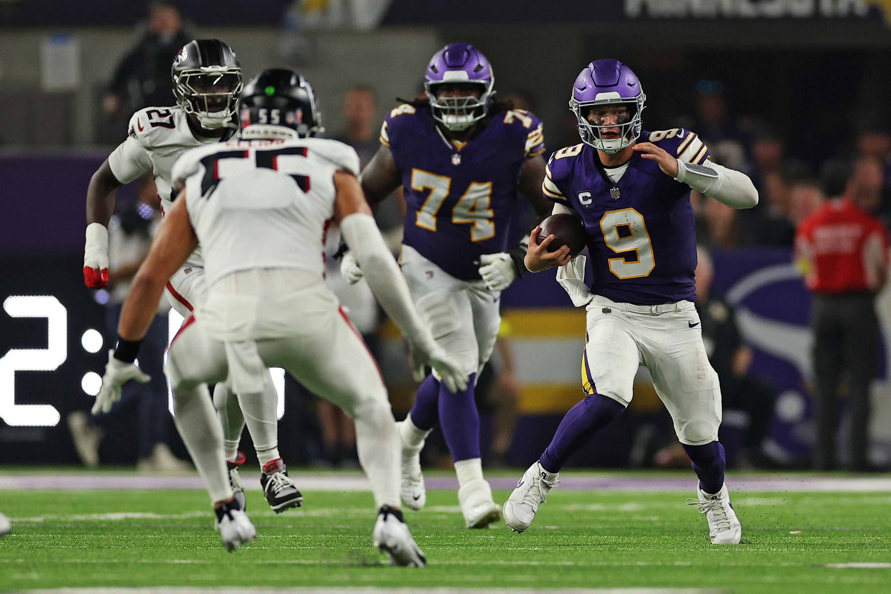 Sep 14, 2025; Minneapolis, Minnesota, USA; Minnesota Vikings quarterback J.J. McCarthy (9) runs the ball during the second half against the Atlanta Falcons with linebacker Kaden Elliss (55) staring him down at U.S. Bank Stadium.