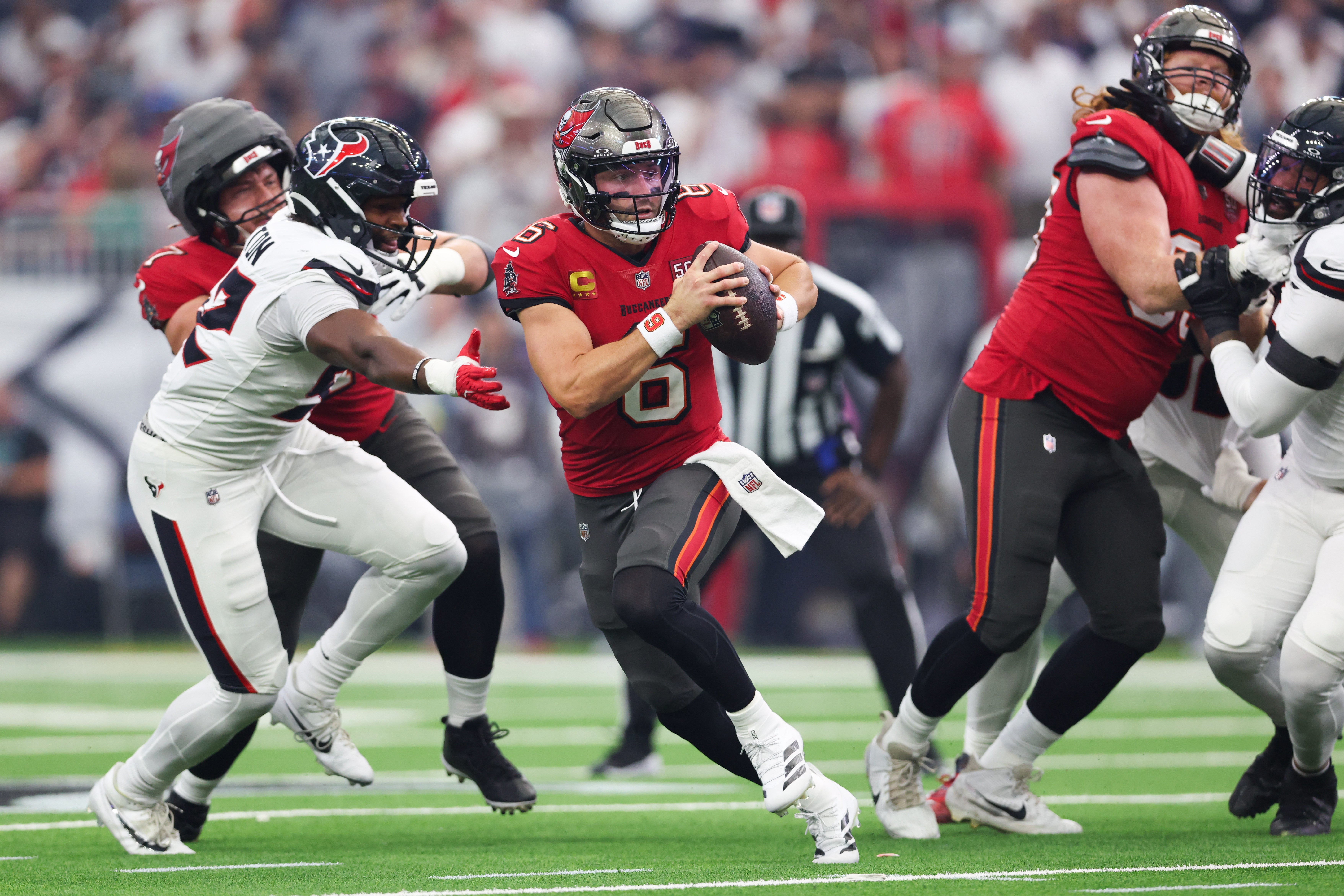 Sep 15, 2025; Houston, Texas, USA; Tampa Bay Buccaneers quarterback Baker Mayfield (6) evades pressure and looks to pass during the first quarter against the Houston Texans at NRG Stadium.