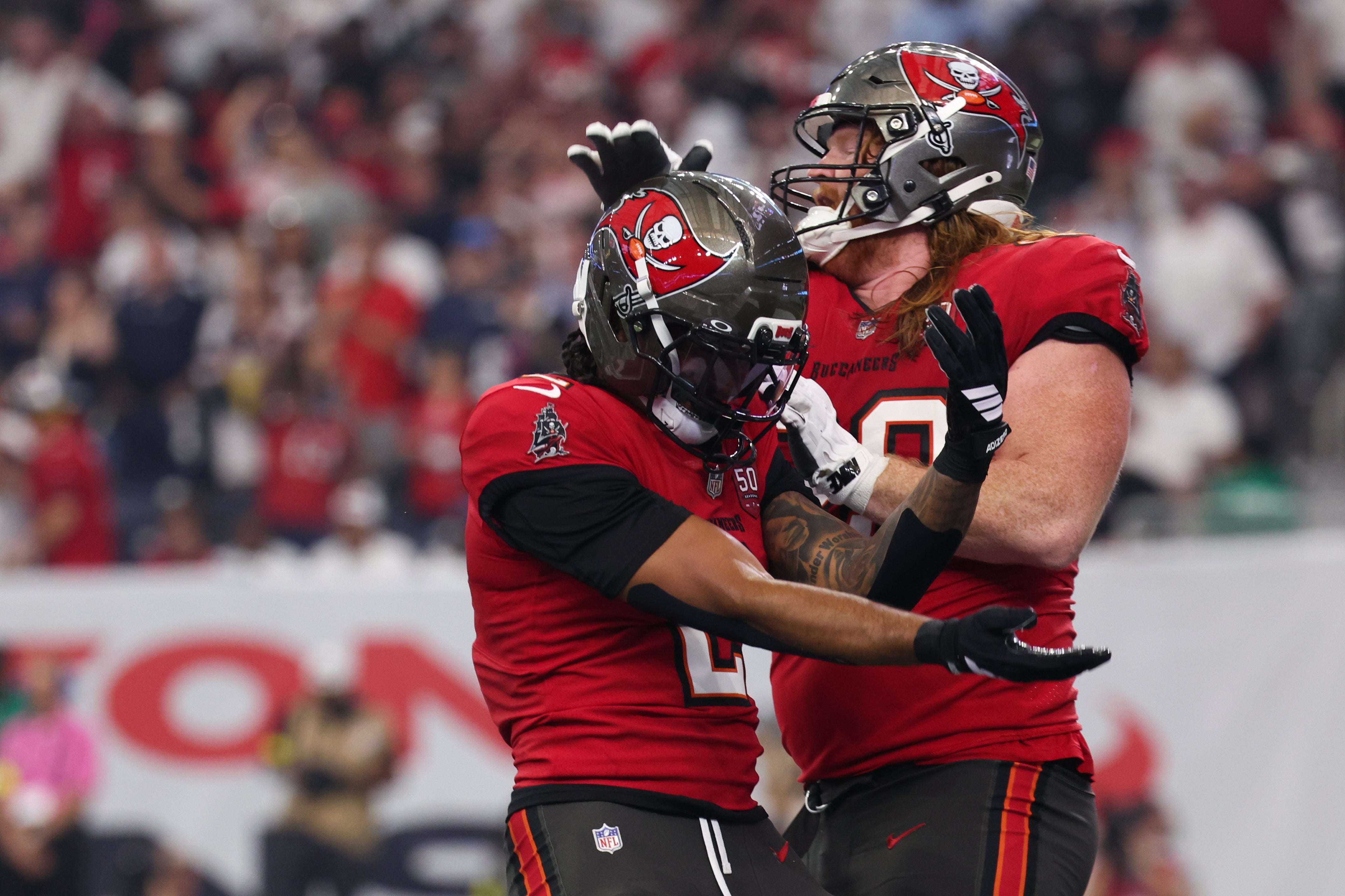 Sep 15, 2025; Houston, Texas, USA; Tampa Bay Buccaneers wide receiver Emeka Egbuka (2) celebrates with Tampa Bay Buccaneers guard Cody Mauch (69) after scoring a touchdown during the second quarter against the Houston Texans at NRG Stadium.