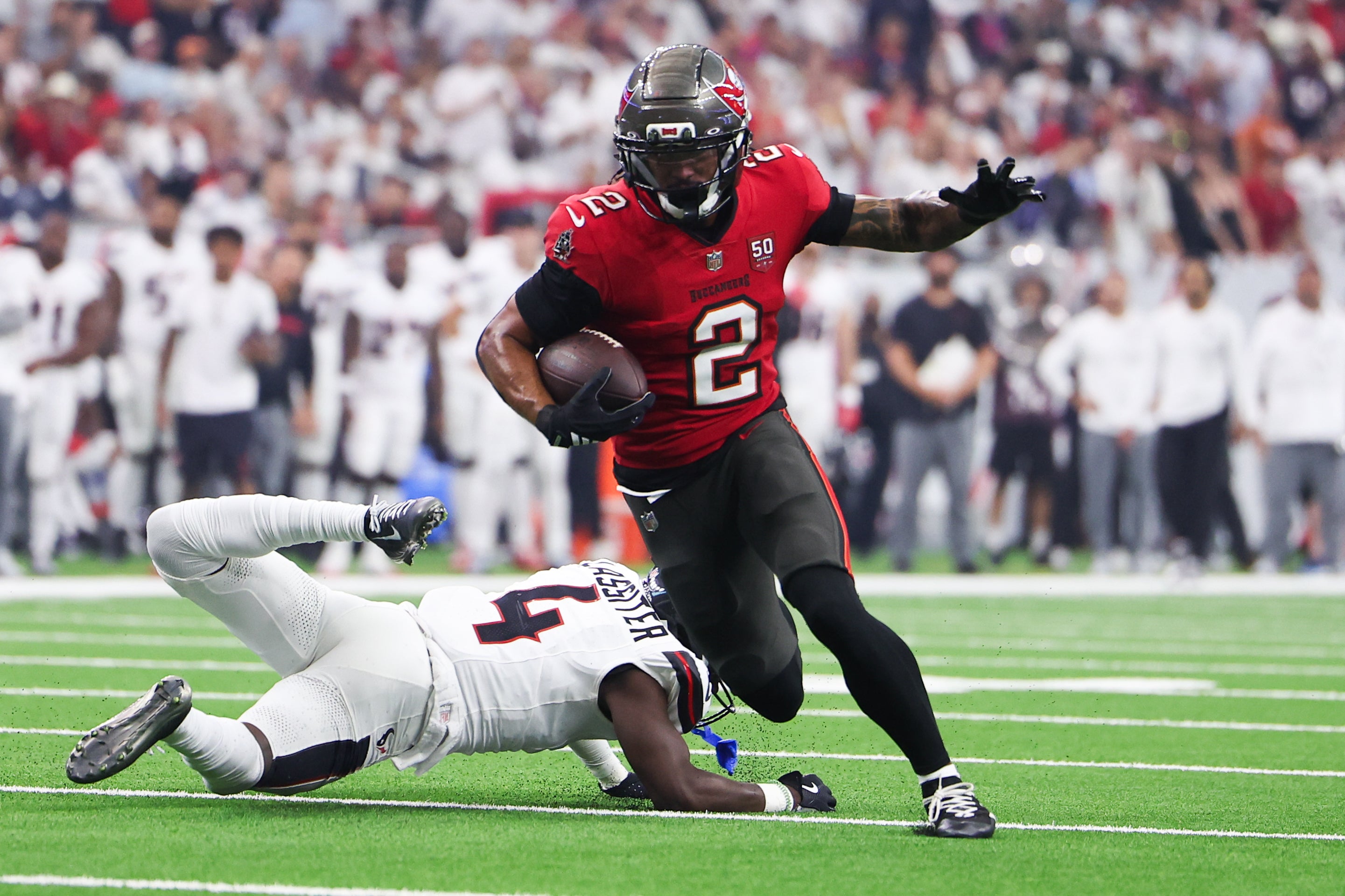 Sep 15, 2025; Houston, Texas, USA; Tampa Bay Buccaneers wide receiver Emeka Egbuka (2) runs for a touchdown as Houston Texans cornerback Kamari Lassiter (4) defends during the second quarter at NRG Stadium.