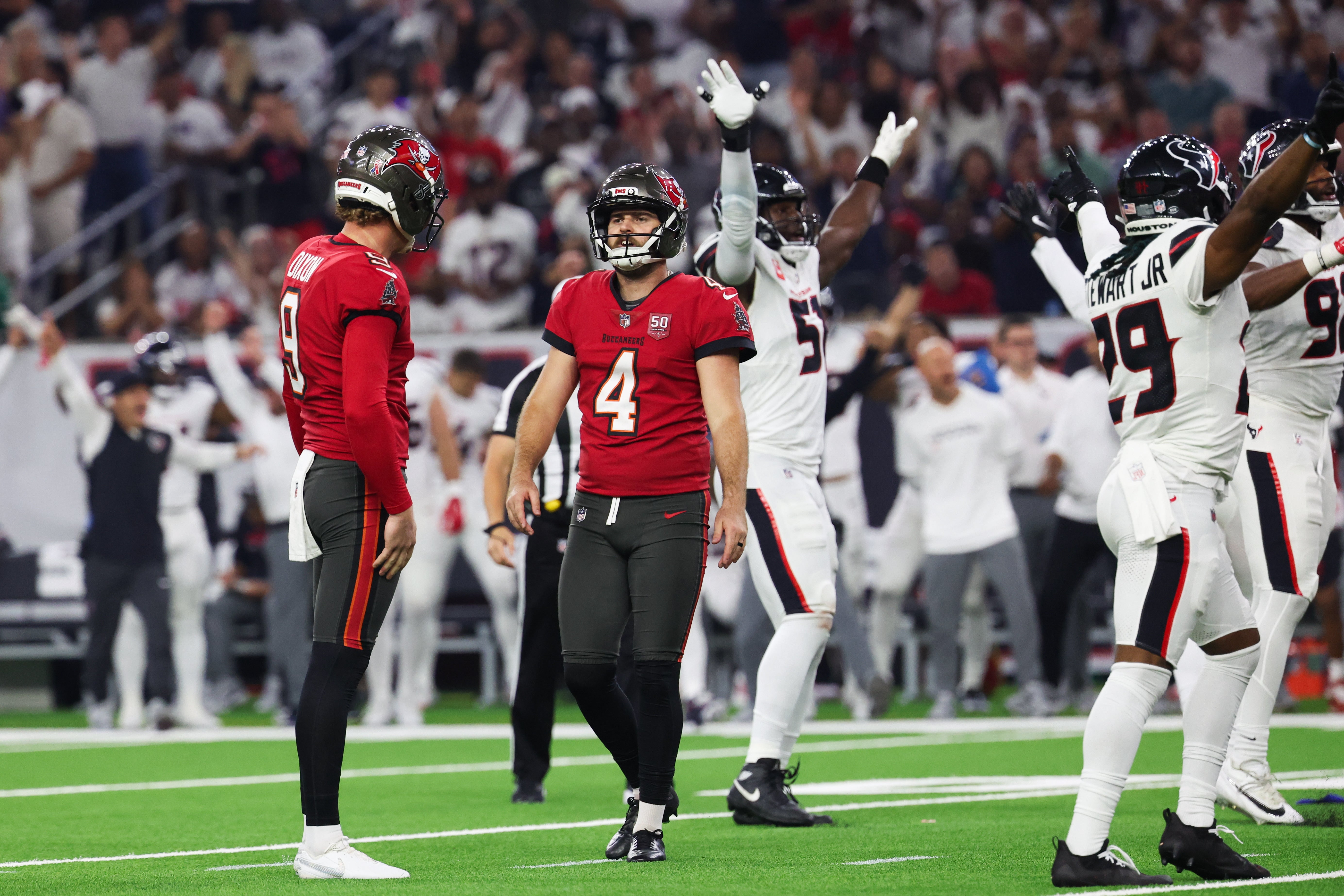 Sep 15, 2025; Houston, Texas, USA; Tampa Bay Buccaneers place kicker Chase McLaughlin (4) looks on after missing a field goal as Houston Texans players celebrate during the fourth quarter at NRG Stadium.
