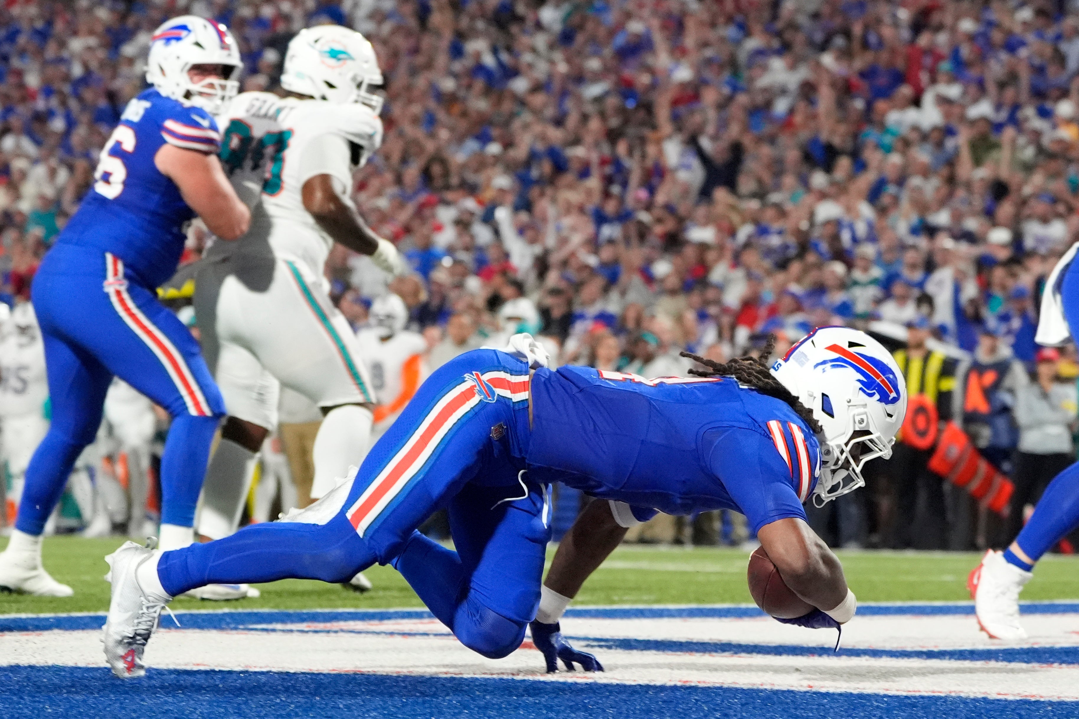 Sep 18, 2025; Orchard Park, New York, USA; Buffalo Bills running back James Cook (4) scores a touchdown against the Miami Dolphins in the third quarter at Highmark Stadium.