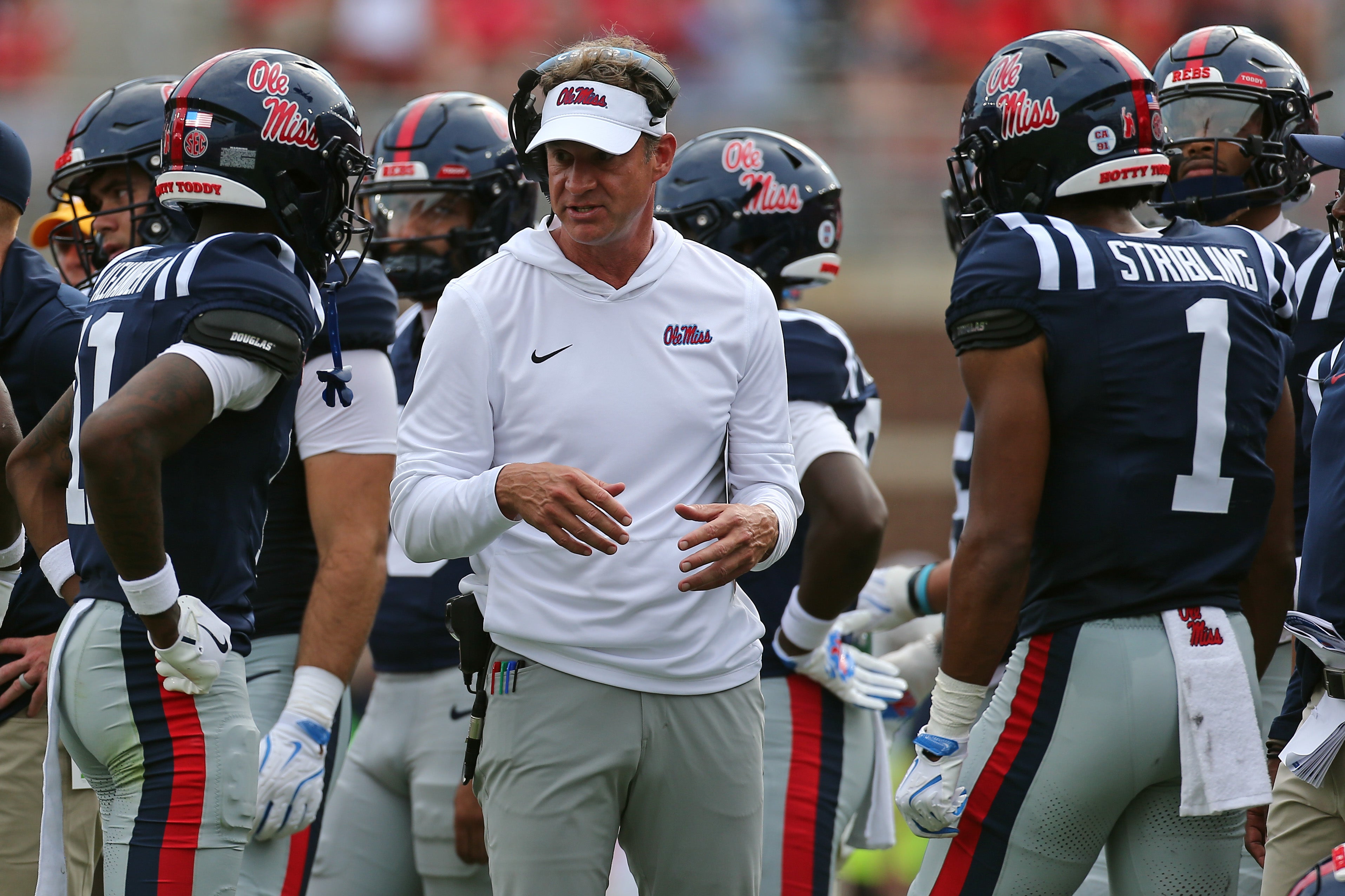 Sep 20, 2025; Oxford, Mississippi, USA; Mississippi Rebels head coach Lane Kiffin (middle) talks with wide receivers Deuce Alexander (11) and De'Zhaun Stribling (1) during a time out during the second quarter against the Tulane Green Wave at Vaught-Hemingway Stadium.