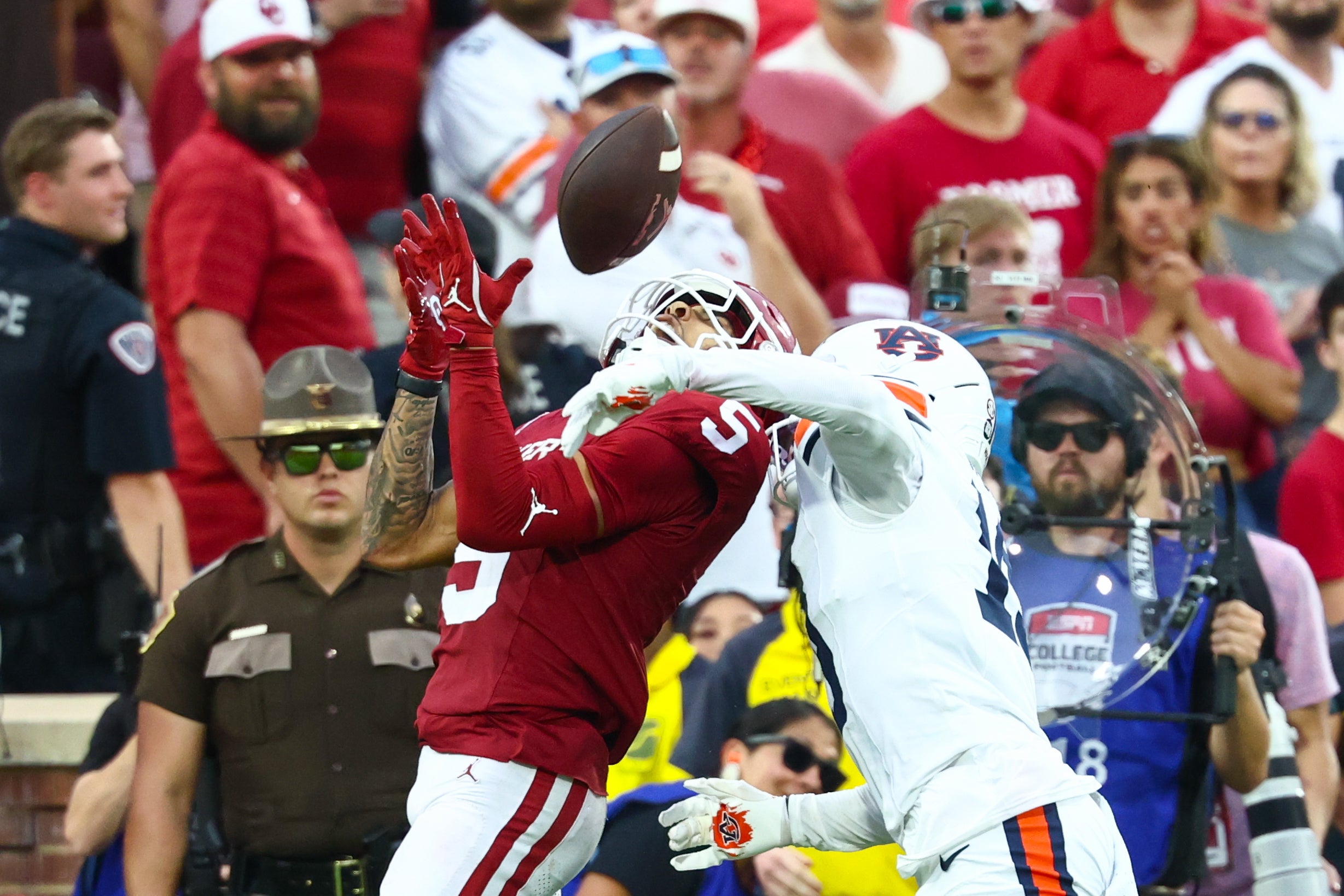 Sep 20, 2025; Norman, Oklahoma, USA; Oklahoma Sooners wide receiver Isaiah Sategna III (5) makes a catch past Auburn Tigers safety Sylvester Smith (19) during the fourth quarter at Gaylord Family-Oklahoma Memorial Stadium.