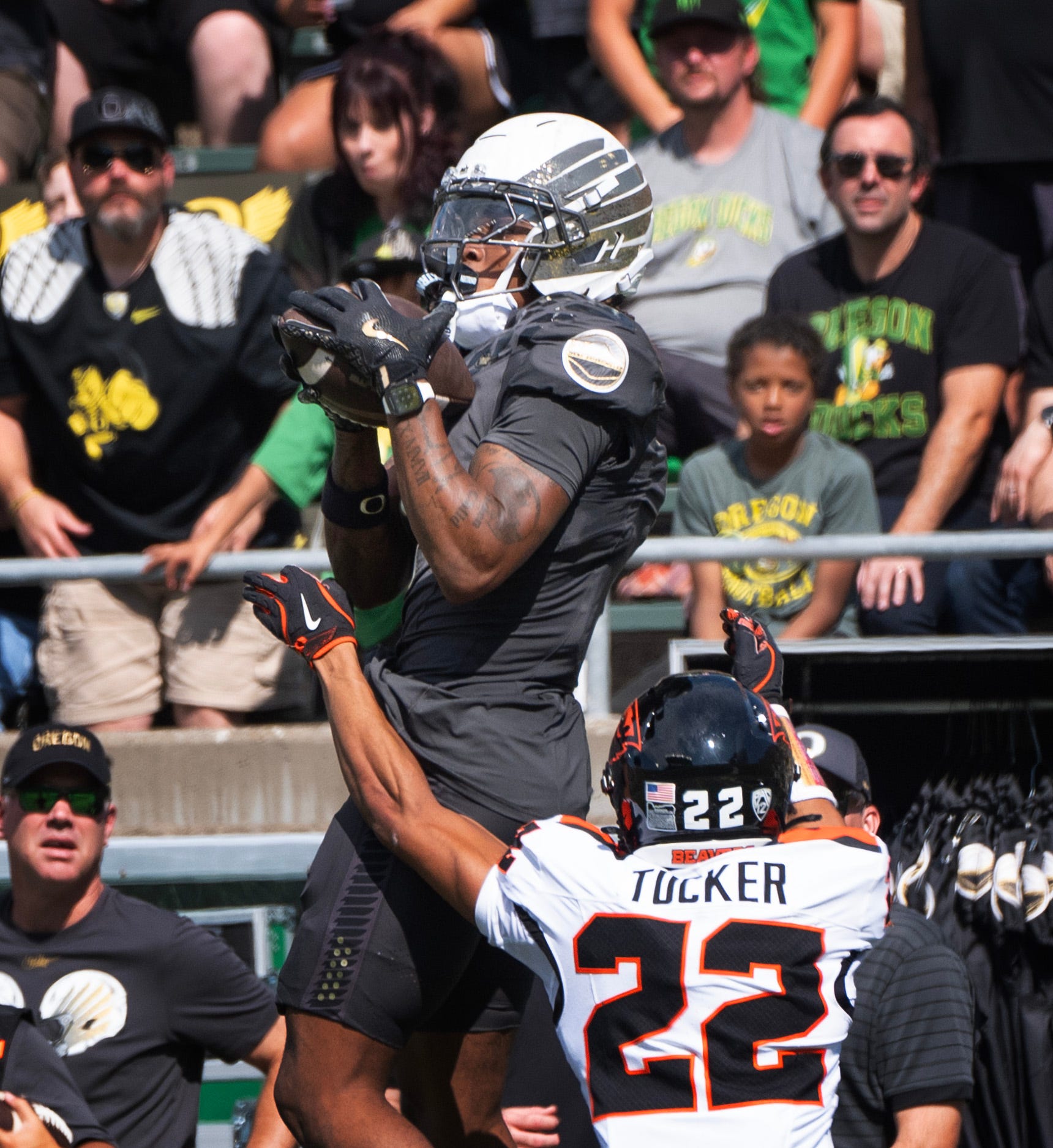 Oregon’s Dakorien Moore, left, pulls down a pass under pressure from Oregon State’s Jalil Tucker on the way to the first touchdown of the game.