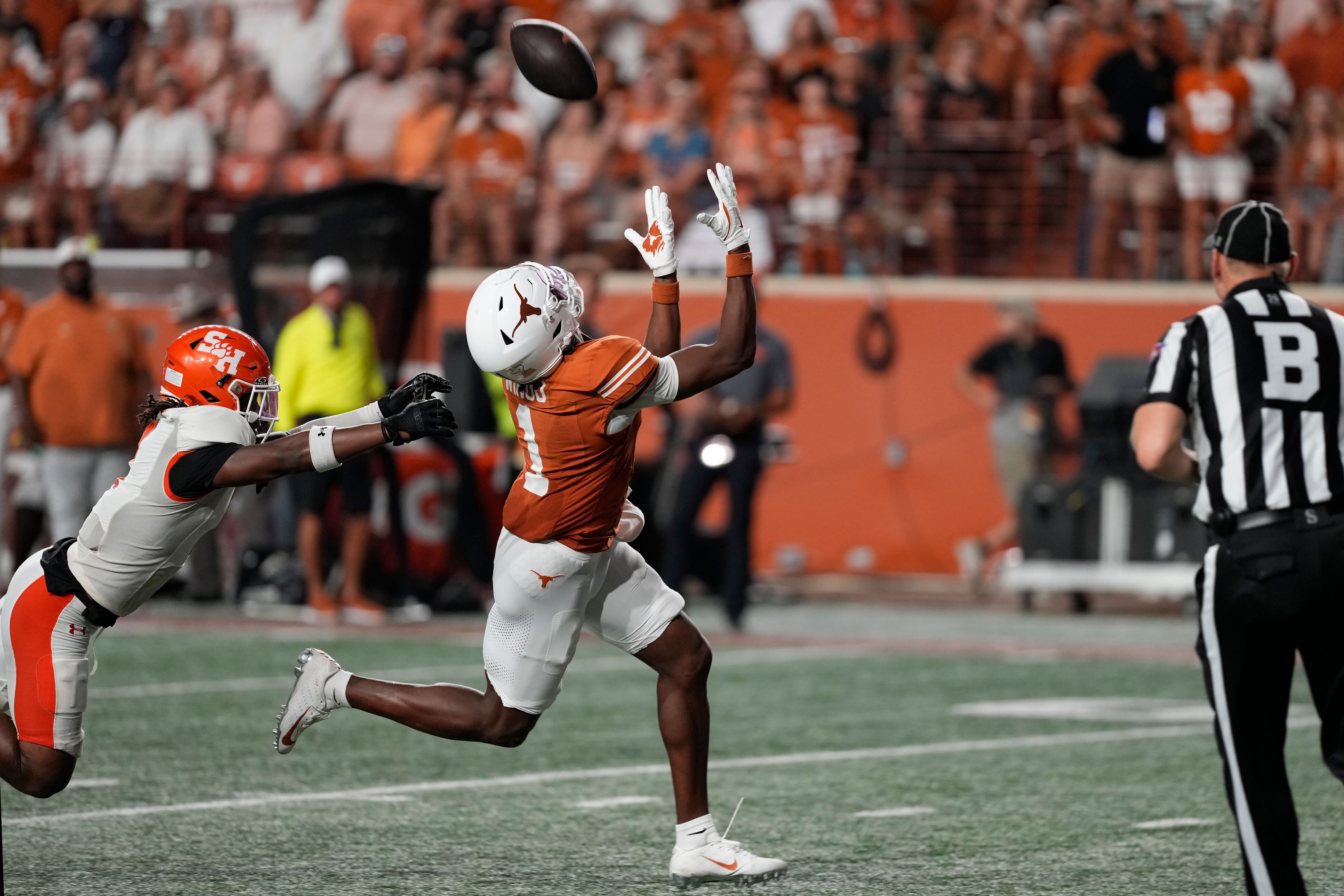 Sep 20, 2025; Austin, Texas, USA; Texas Longhorns wide receiver Ryan Wingo (1) catches a pass for a touchdown over Sam Houston Bearkats linebacker Emon Allen (7) during the second half at Darrell K Royal-Texas Memorial Stadium.