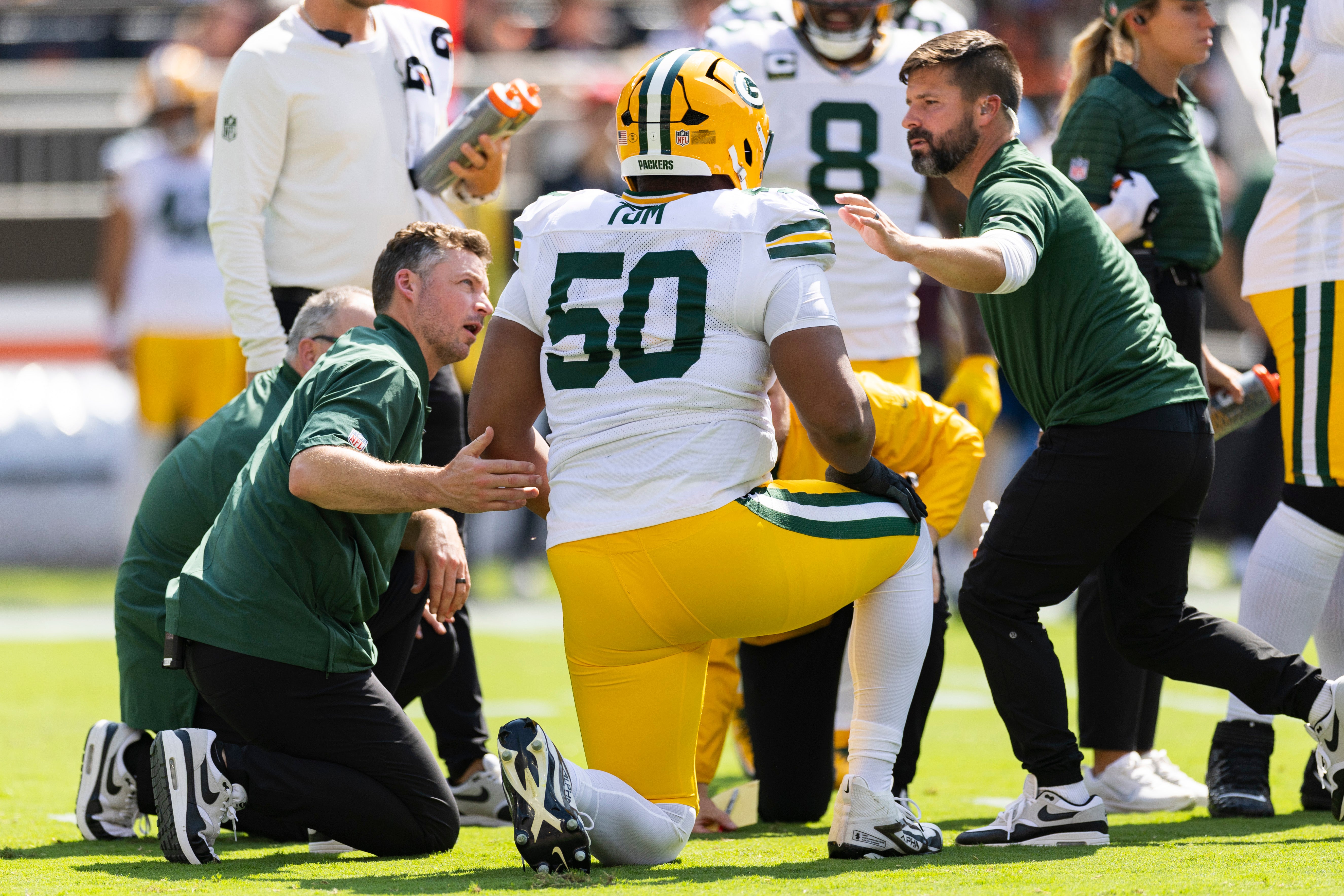 Sep 21, 2025; Cleveland, Ohio, USA; Green Bay Packers offensive tackle Zach Tom (50) is attended to by medical personnel for an on field injury during the first quarter against the Cleveland Browns at Huntington Bank Field.