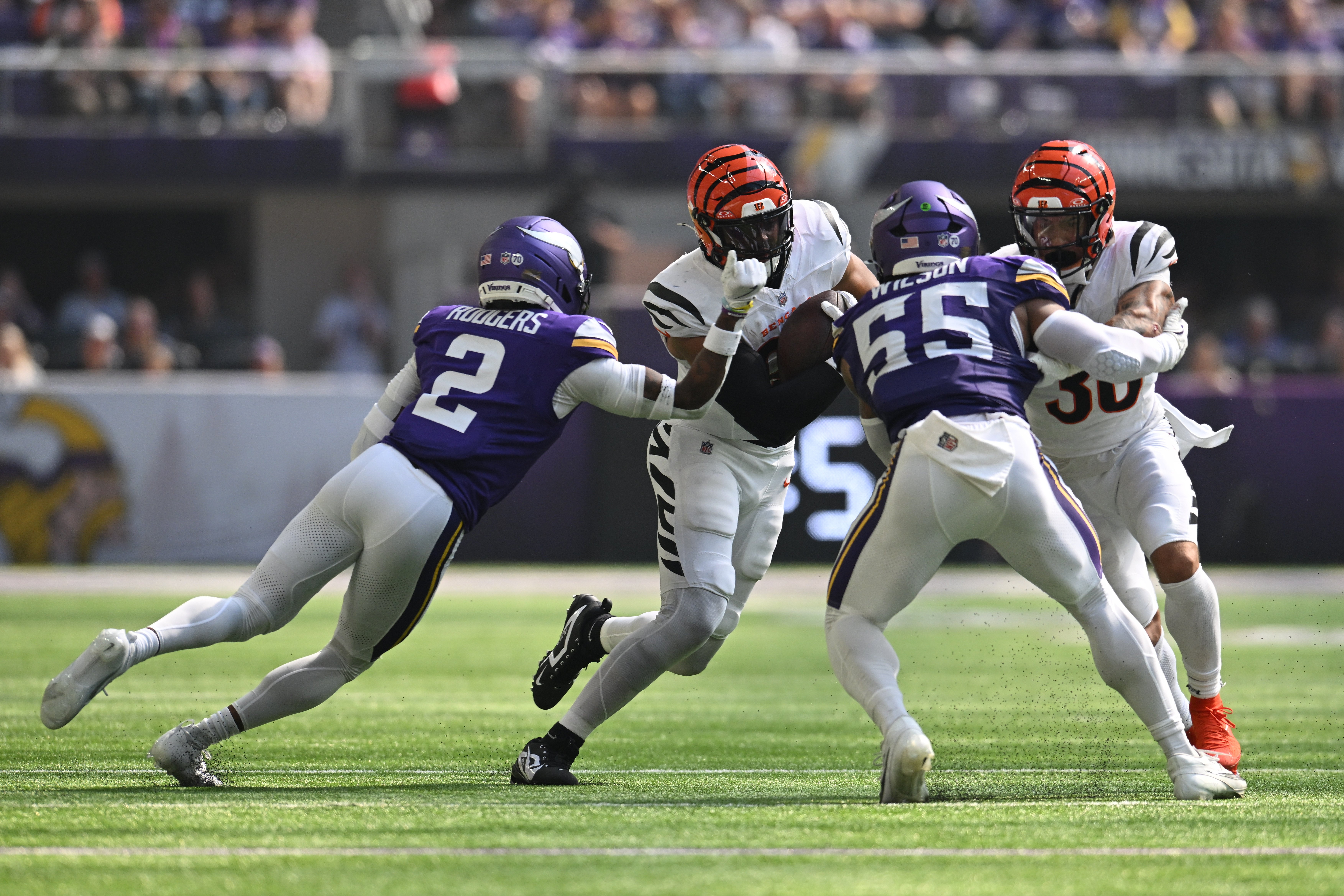 Sep 21, 2025; Minneapolis, Minnesota, USA; Minnesota Vikings cornerback Isaiah Rodgers (2) prepares to punch the ball out as Cincinnati Bengals tight end Noah Fant (86) runs after the catch during the first half at U.S. Bank Stadium.