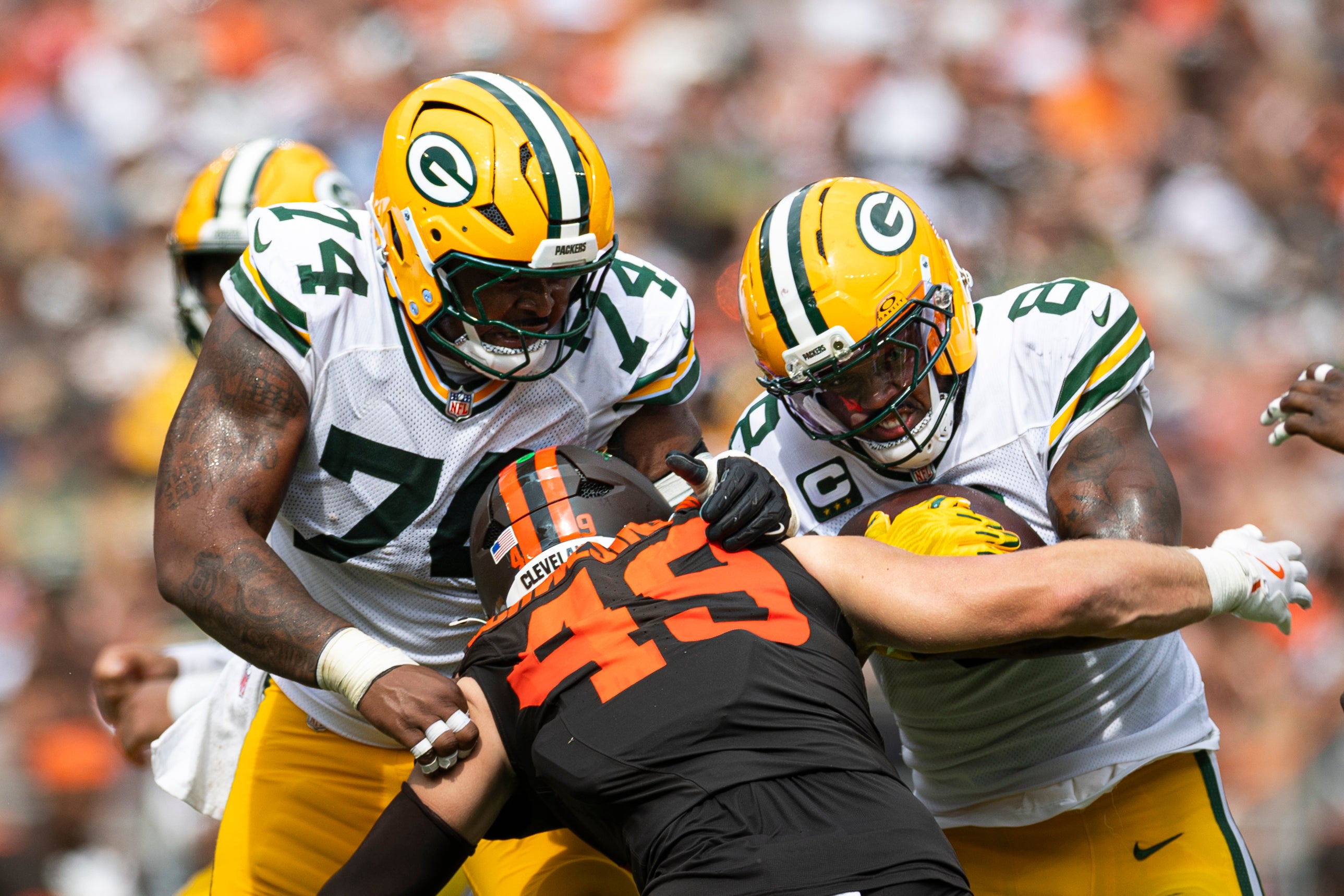 Sep 21, 2025; Cleveland, Ohio, USA; Green Bay Packers running back Josh Jacobs (8) runs the ball as guard Elgton Jenkins (74) blocks Cleveland Browns linebacker Carson Schwesinger (49) during the third quarter at Huntington Bank Field.
