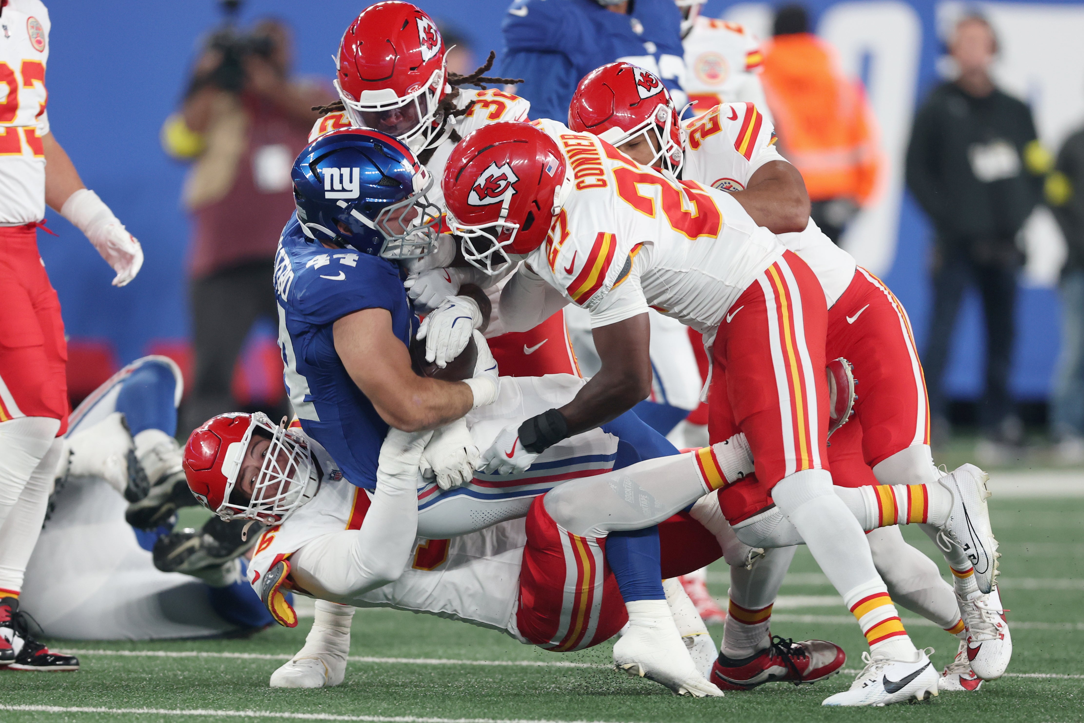 Kansas City Chiefs defensive end George Karlaftis (56) and defensive back Chamarri Conner (27) and linebacker Nick Bolton (32) tackle New York Giants running back Cam Skattebo (44) in the first quarter at MetLife Stadium.